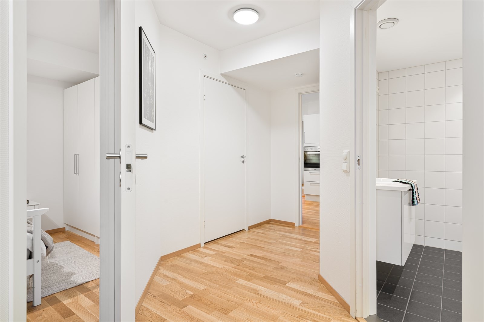 Gang med adkomst til bad/vaskerom, hovedsoverom og bod. Skyvedør inn til stue/kjøkken Galleribilde