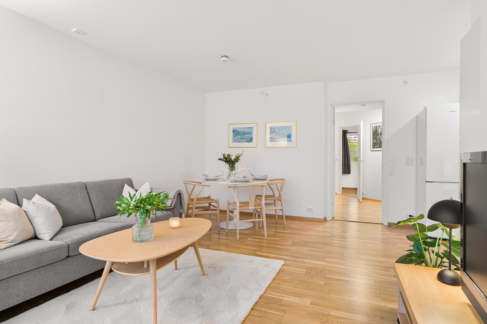 Stue og kjøkken i åpen løsning med plass til både sofagruppe og spisebord. Galleribilde