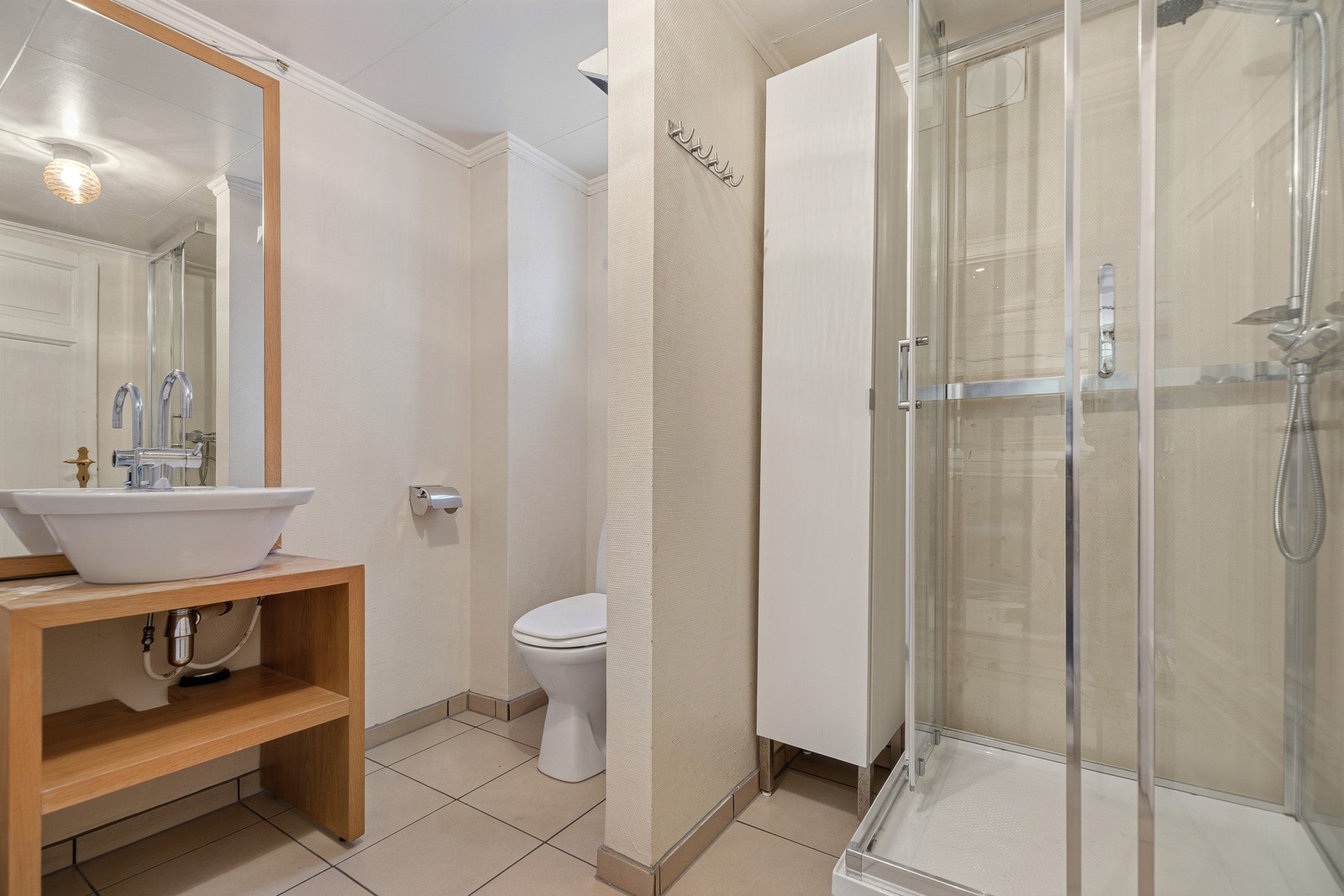 Bad i første etasje med tilgang fra entréen med toalett, dusjkabinett og servant Galleribilde