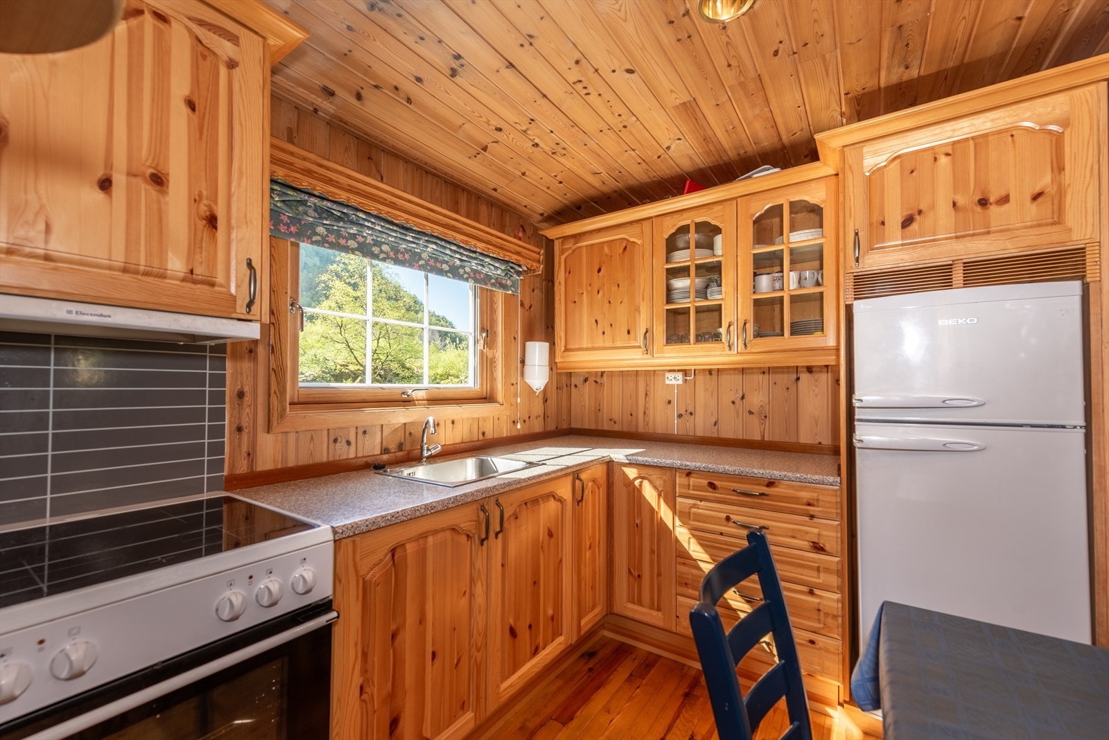 Kjøkken er med profilerte fronter i tre og laminat benkeplate Galleribilde