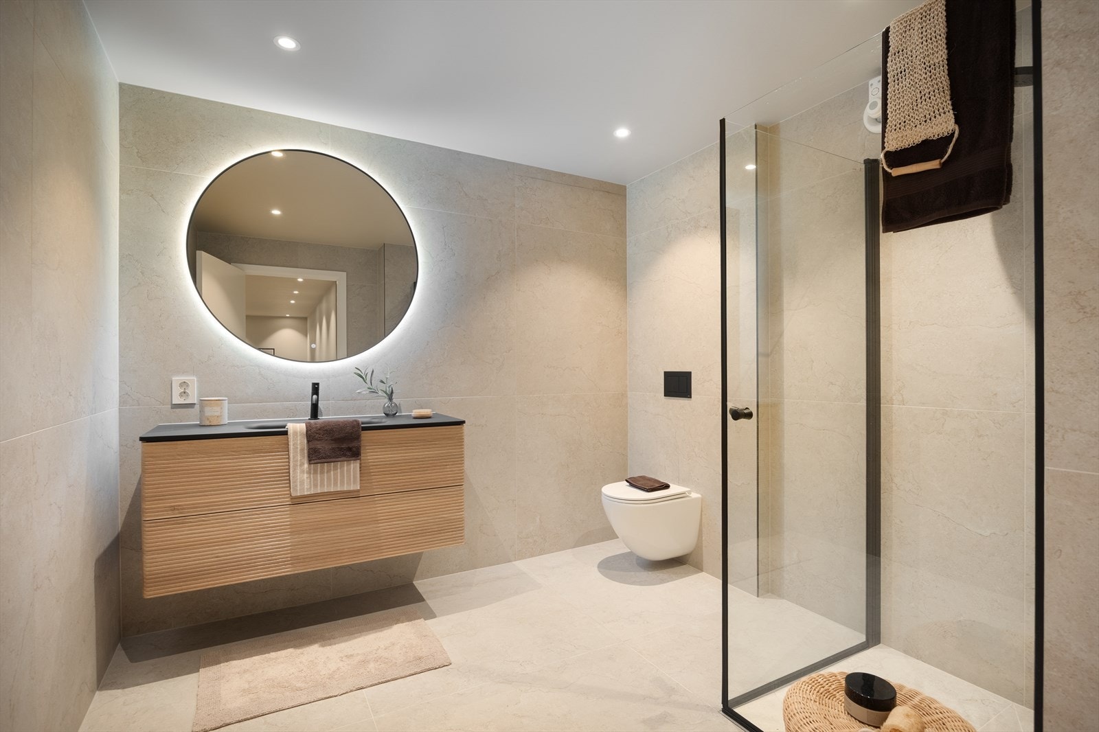 Lekkert bad med storformat fliser, platehimling med lysspotter, vegghengt toalett, dusjløsning i glass og moderne innredning Galleribilde