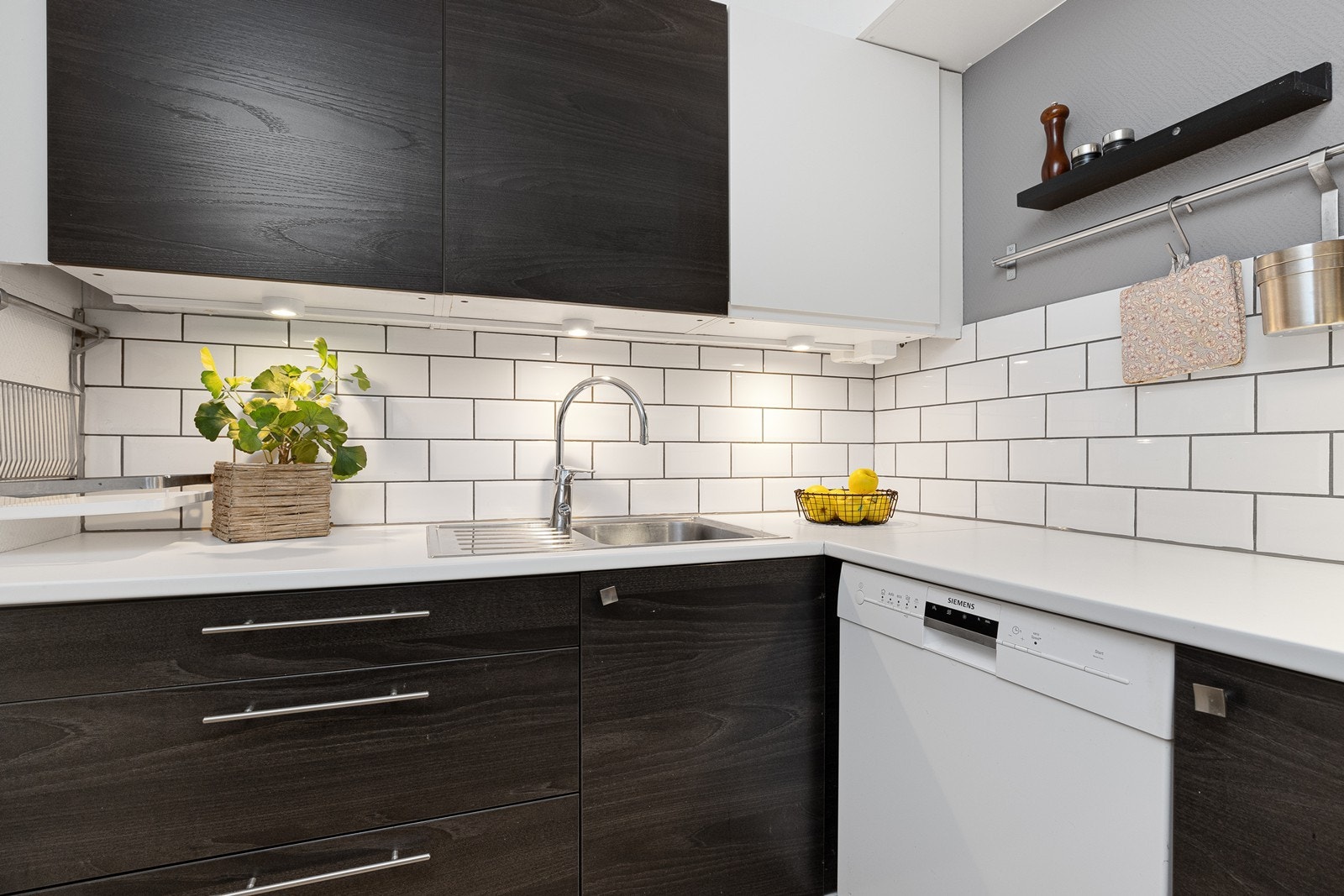 Kjøkkenet har slette, mørktonede fronter og laminerte benkeplater. Galleribilde