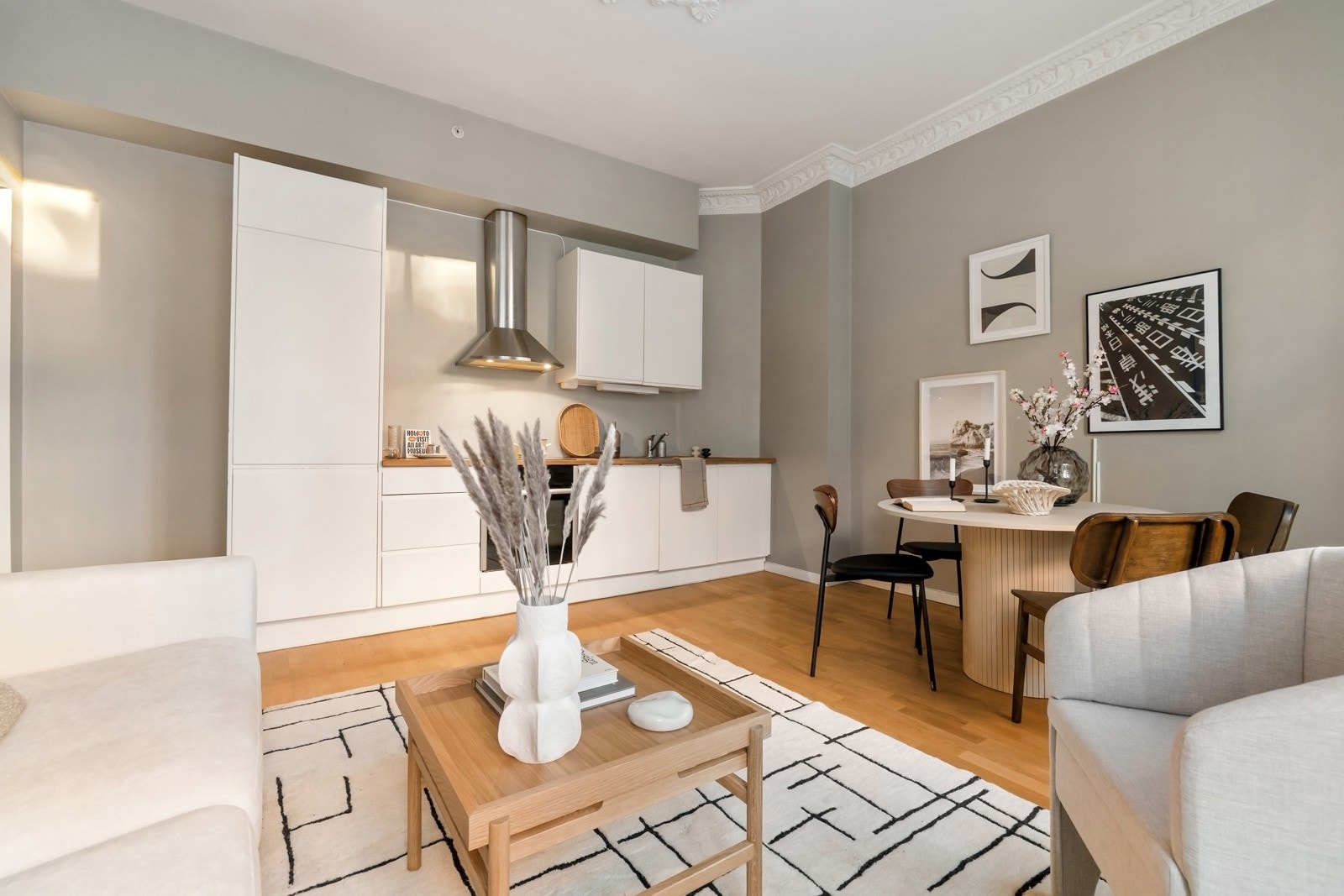 Lyst kjøkken med hvite glatte fronter og benkeplate i heltre med nedfelt vaskekum. Galleribilde