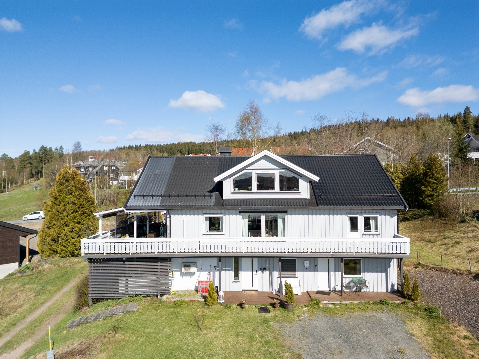 Boligen byr på flott utsikt og gode solforhold, en stor terrasse samt hage med plen og beplantning Galleribilde