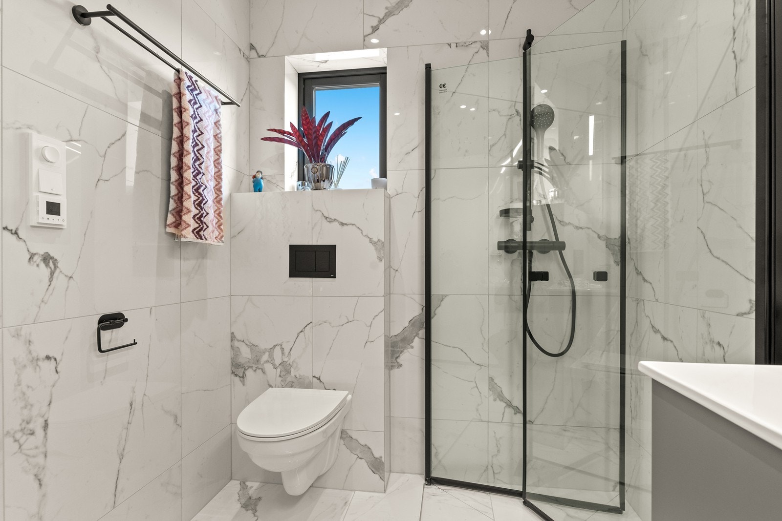 Bad i 2. etasje har vegghengt toalett og dusjhjørne med innskyvbare glassvegger. Sorte detaljer gir rommet et moderne og eksklusivt preg. Varmekabler i gulvet for ekstra komfort. Galleribilde