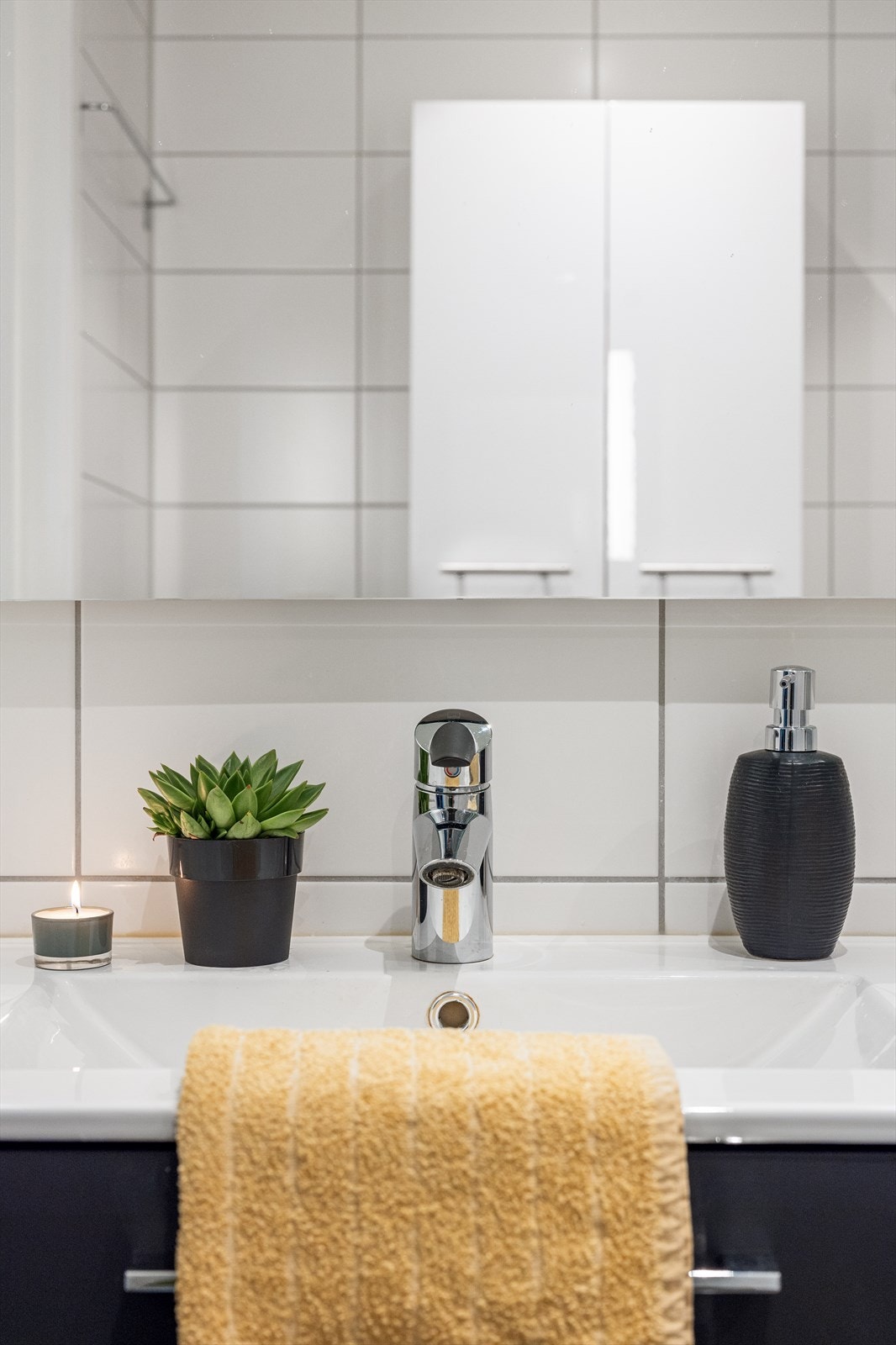 Innredningen består av høyskap med hvite høyglansfronter og servantskap med mørke, glatte fronter og hvit keramisk servant med ettgreps blandebatteri i rustfritt stål. Galleribilde