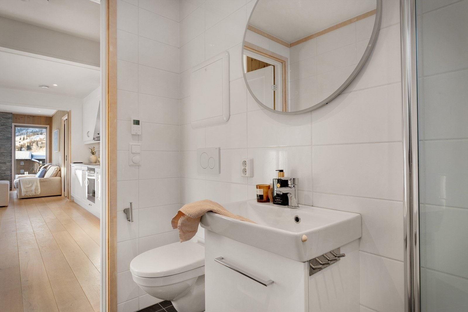 Baderommet er utstyrt med foldedører i dusj, veggtoalett og baderomsinnredning med heldekkende servant, samt belyst speil Galleribilde