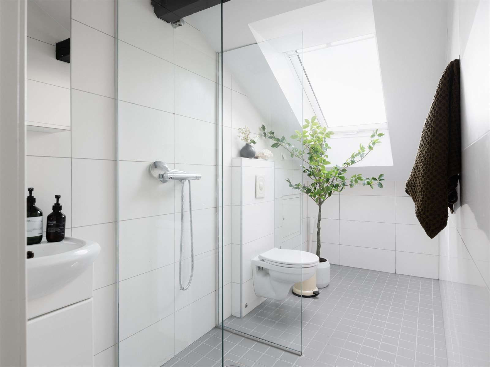 Flislagt baderom i en tidsnøytral utførelse fra byggeår (2008). Opplegg for vaskemaskin i hjørnet. Galleribilde