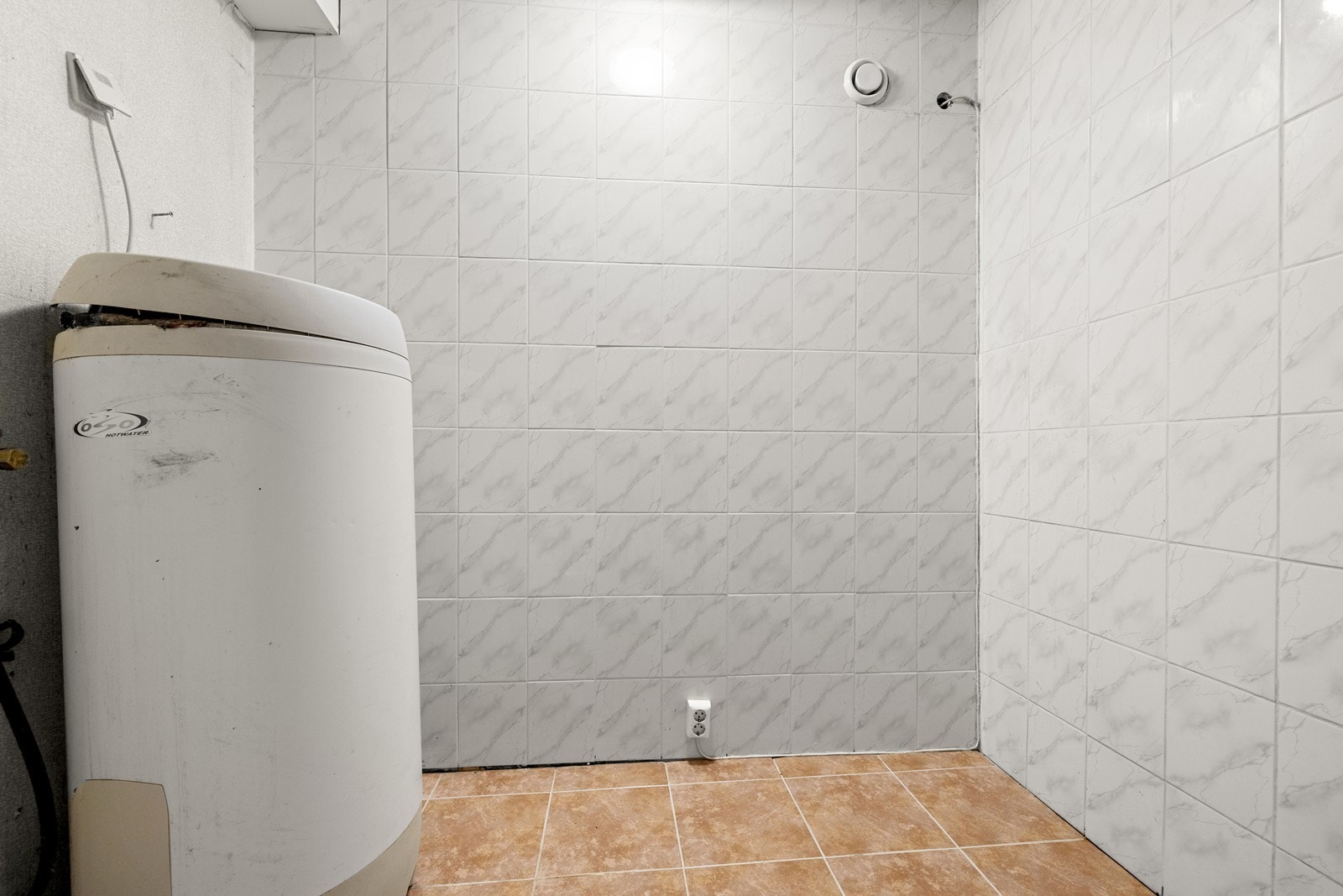 Vaskerom med opplegg for vaskemaskin og varmtvannsbereder. Galleribilde