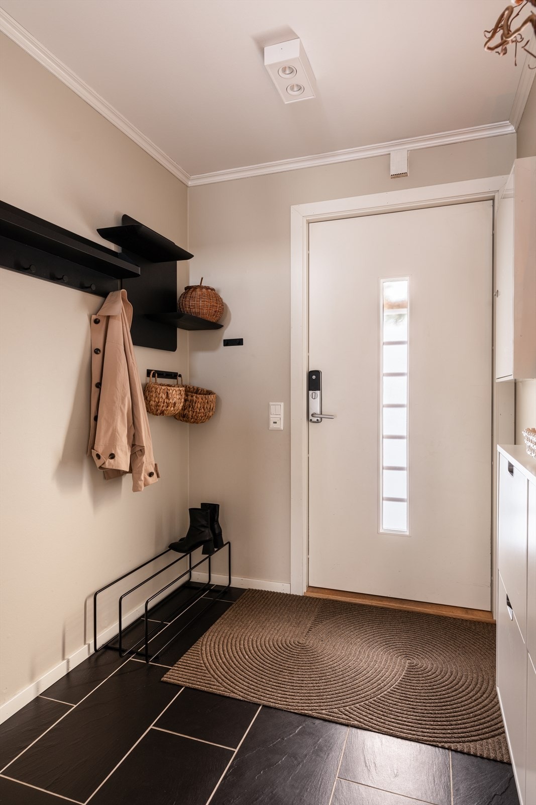 Innbydende entré med flislagt gulv med gulvvarme, malte vegger og malt himling. Galleribilde