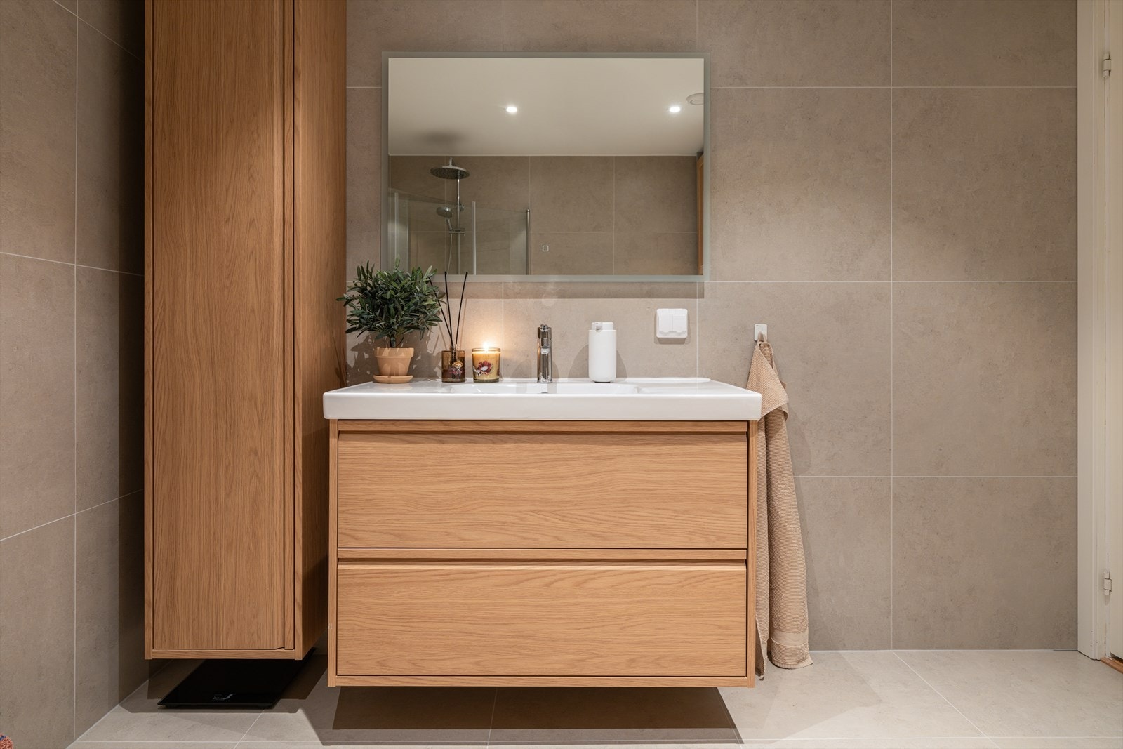 Innredningen består av stilrent servantskap med nedfelt servant, praktisk veggskap og speil med integrert belysning som gir behagelig og funksjonelt lys. Galleribilde