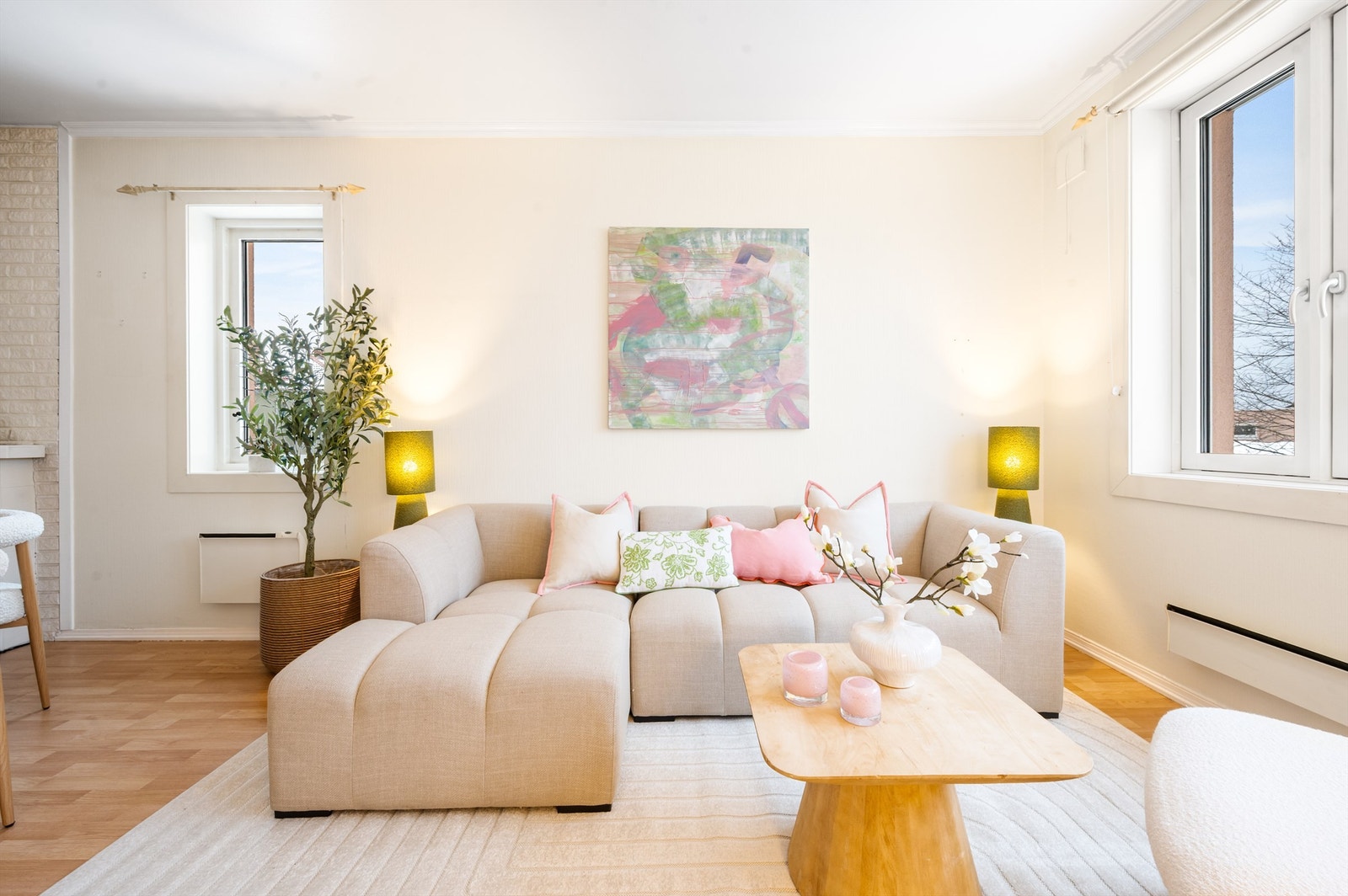 Lyse, malte vegger kombinert med laminatgulv gir et praktisk og vedlikeholdsvennlig uttrykk. Med vinduer på begge sider bades stuen i naturlig lys store deler av dagen, og gir en god romfølelse. Galleribilde