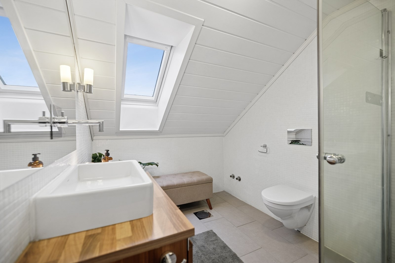 Mosaikkfliser på veggene og downlights i taket gir et stilrent uttrykk. Galleribilde