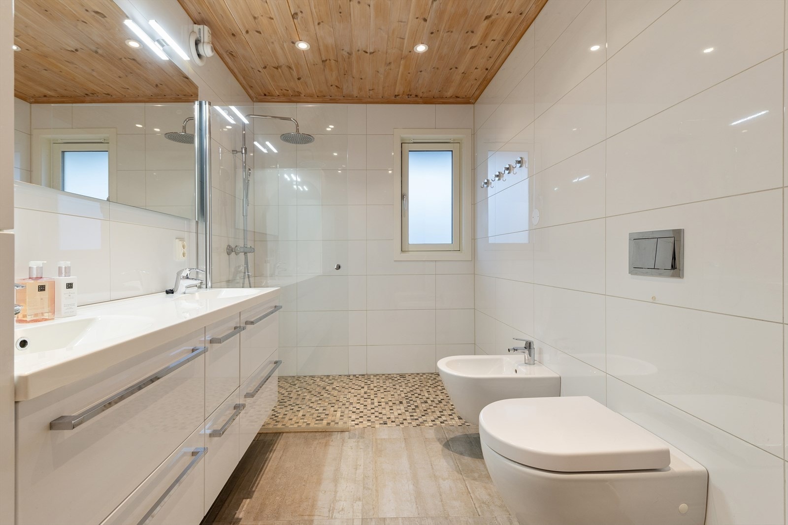 Badet ble pusset opp i 2014 og er delikat innredet med grå fliser på gulv og hvite fliser på vegg. I gulvet har man også varmekabler for ekstra komfort. Galleribilde