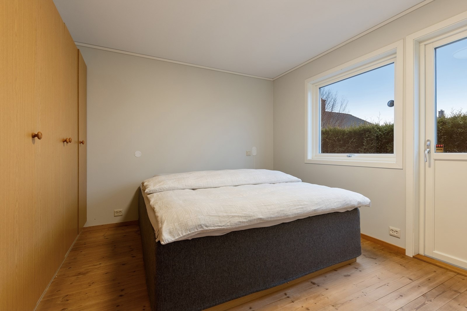 Soverom 1 ligger i første etasje og er utstyrt med god garderobeplass. I tillegg har man god plass til dobbeltseng og utgang til terrassen. Galleribilde