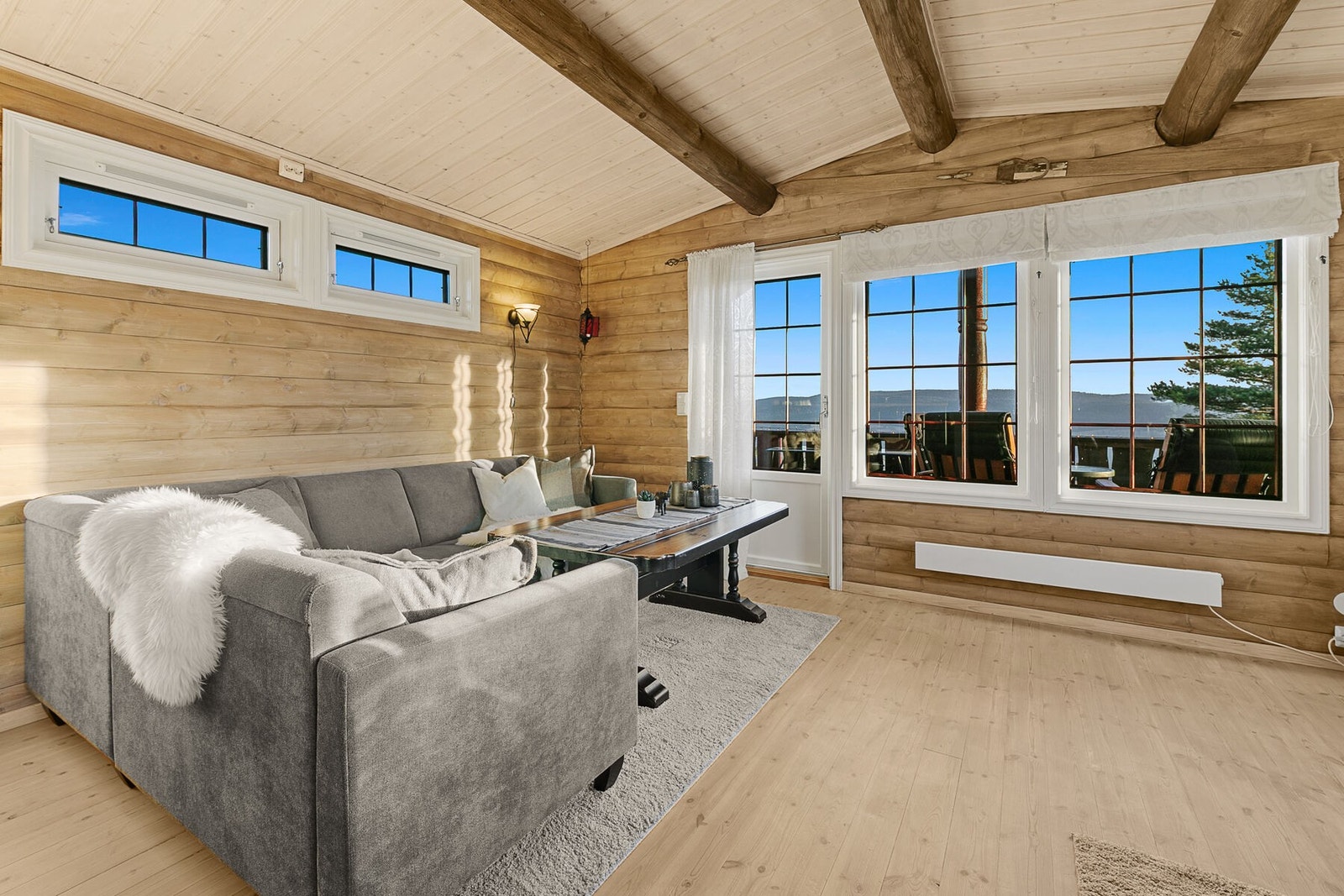 Hytta fremstår i klassisk hyttestil, med enstavs heltrebord på gulv, vegger med med trepanel og synlige bjelker i himling. Galleribilde