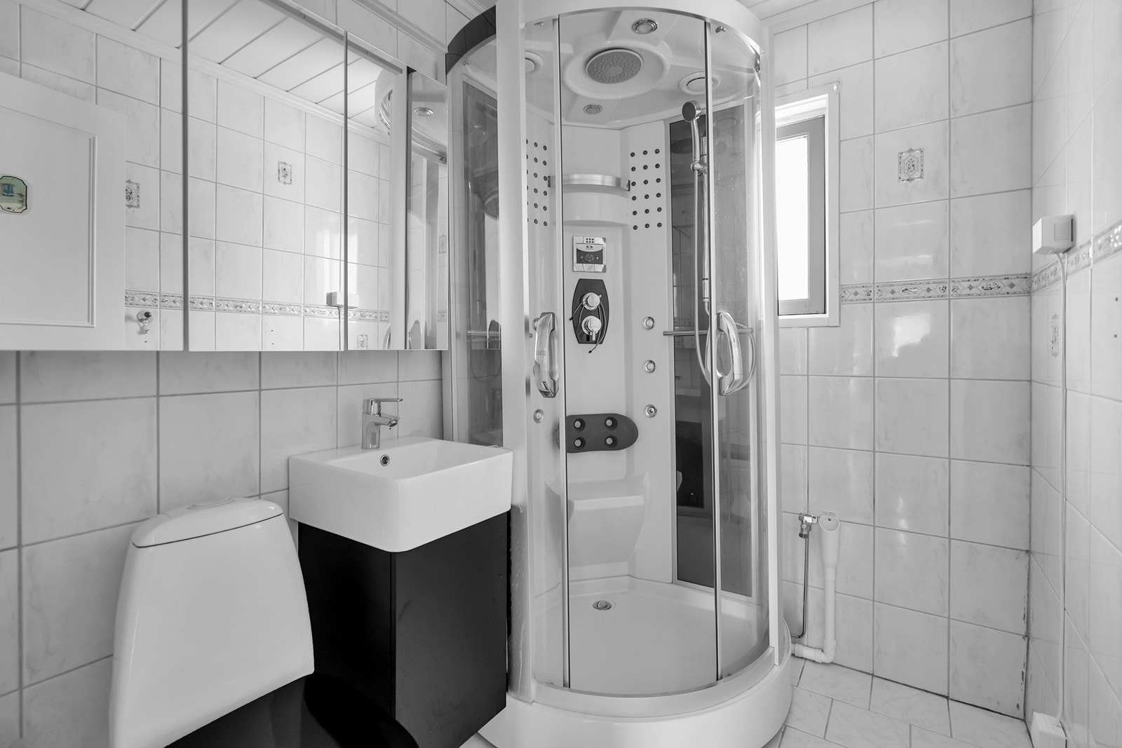 Lyst flislagt bad i 1.Etasje. Her er det toalett, innredning med servant, dusjkabinett og opplegg til vaskemaskin Galleribilde