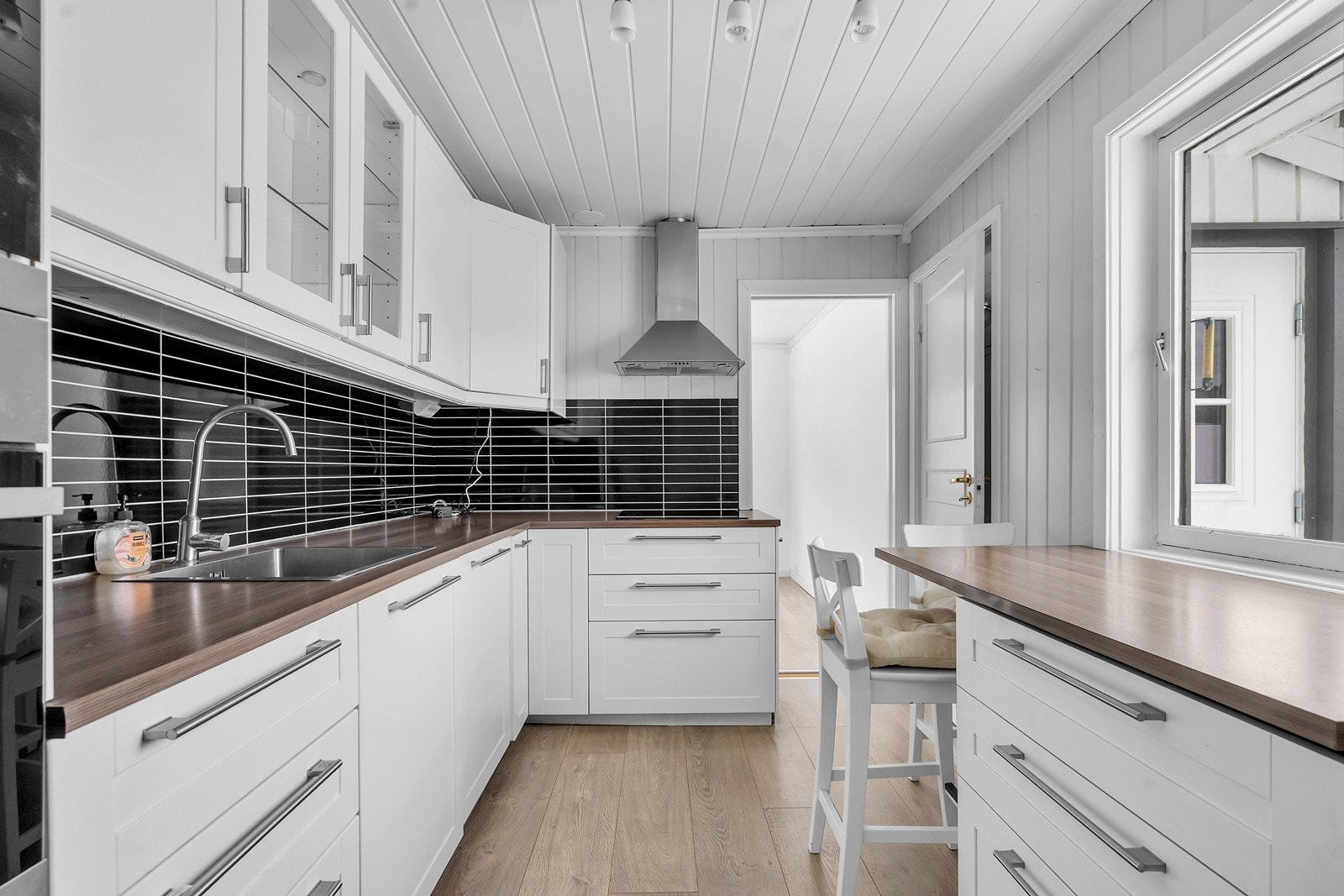 Lyst og pent kjøkken med romslig innredning og spiseplass Galleribilde