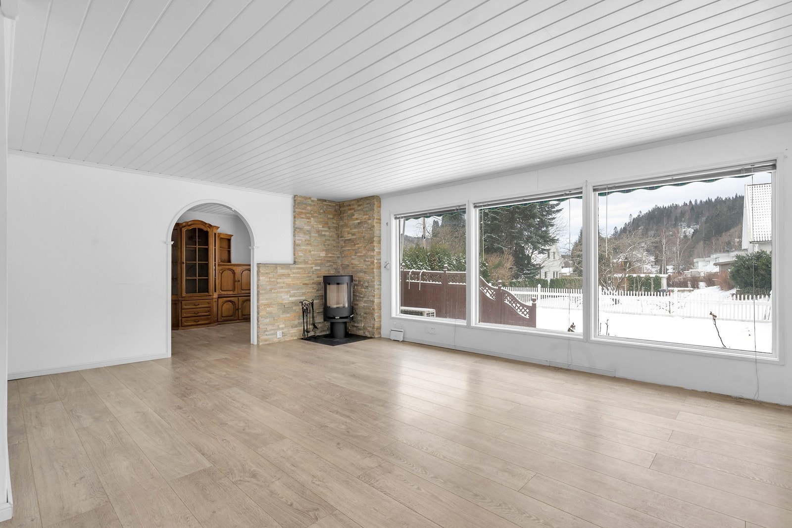 Stor og lys stue med vedovn av nyere dato Galleribilde