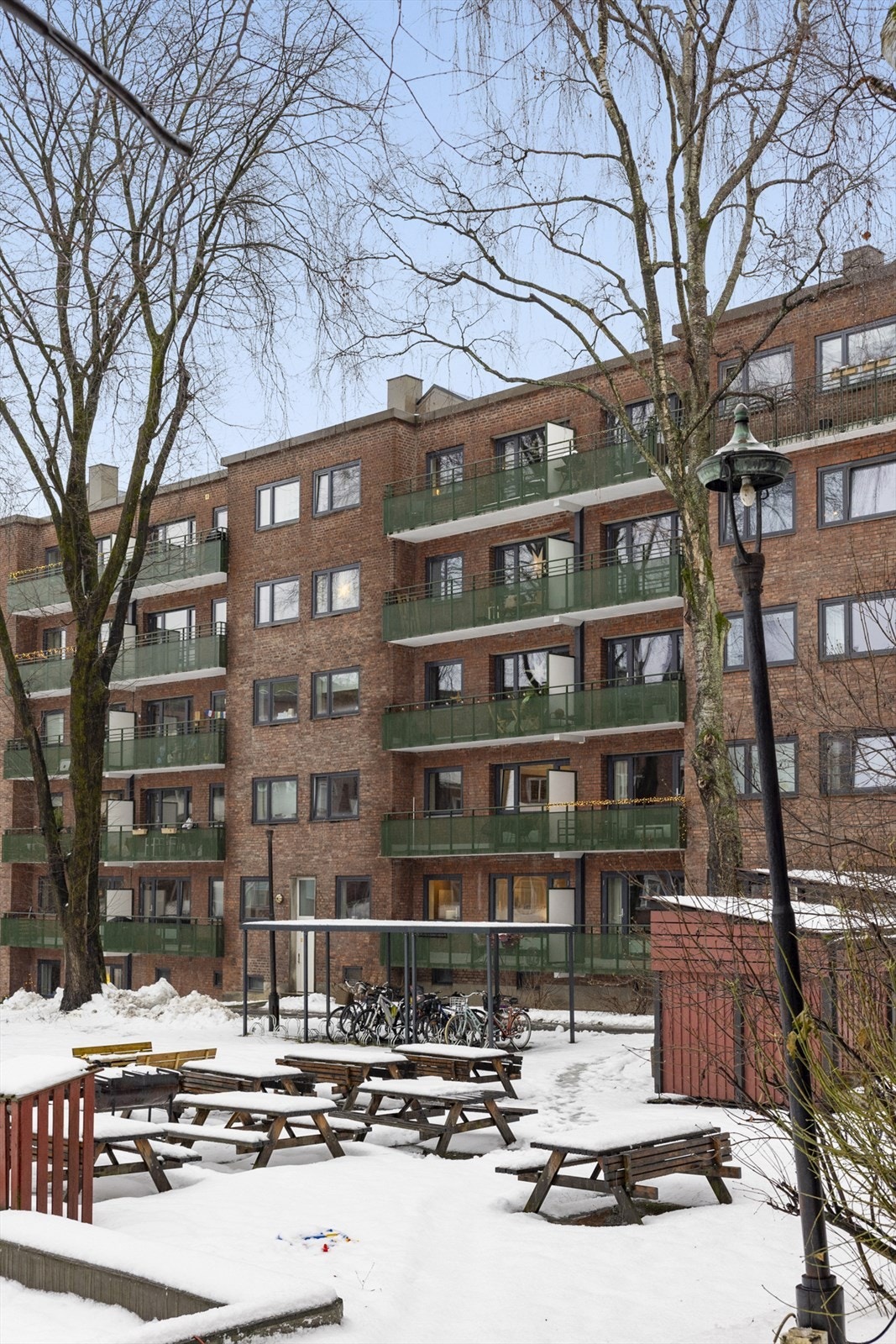 Oversikt over uteområdet i borettslaget med luft mellom byggene og hyggelige soner. Galleribilde