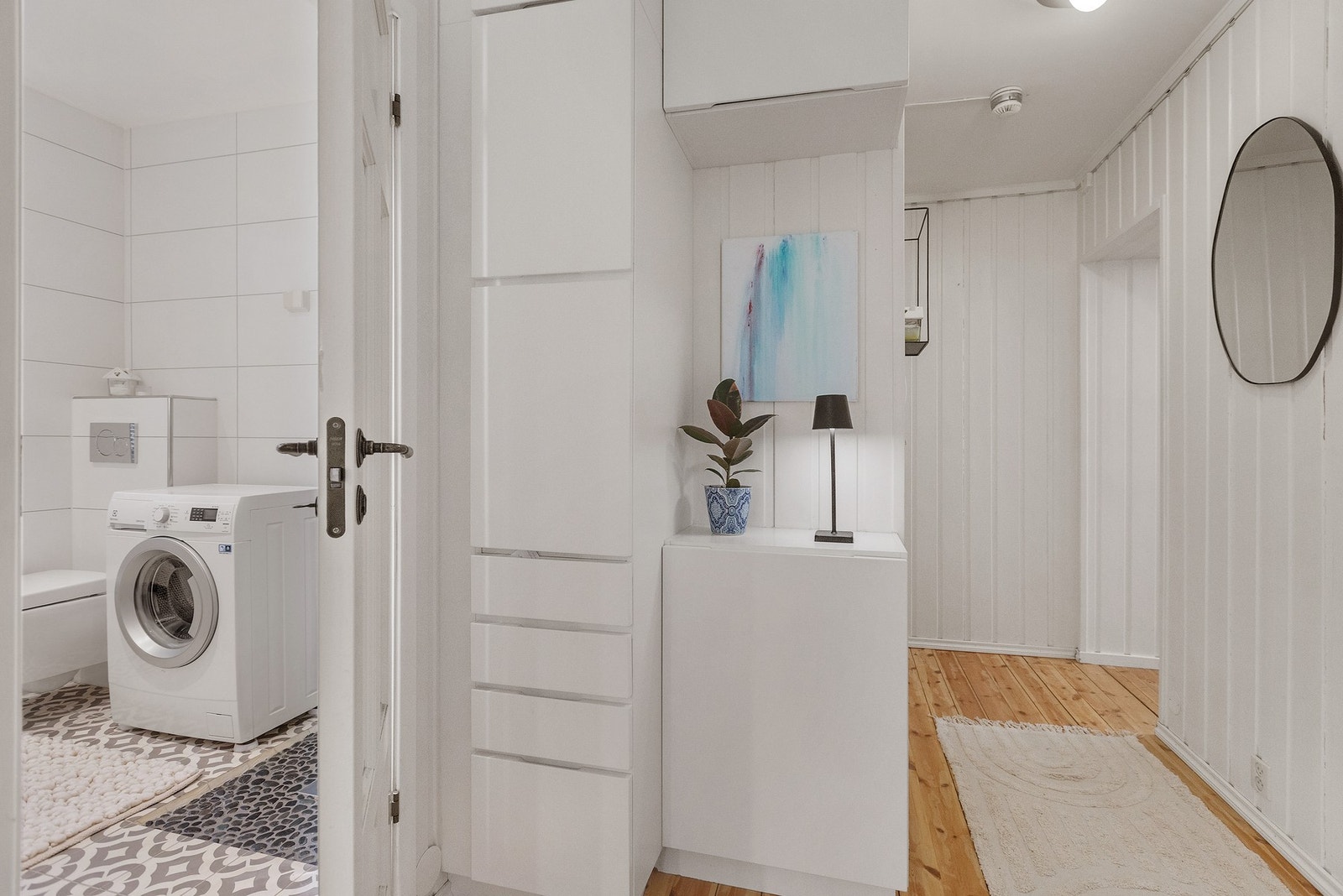 Delikat bad med opplegg for vaskemaskin og praktiske oppbevaringsløsninger. Galleribilde