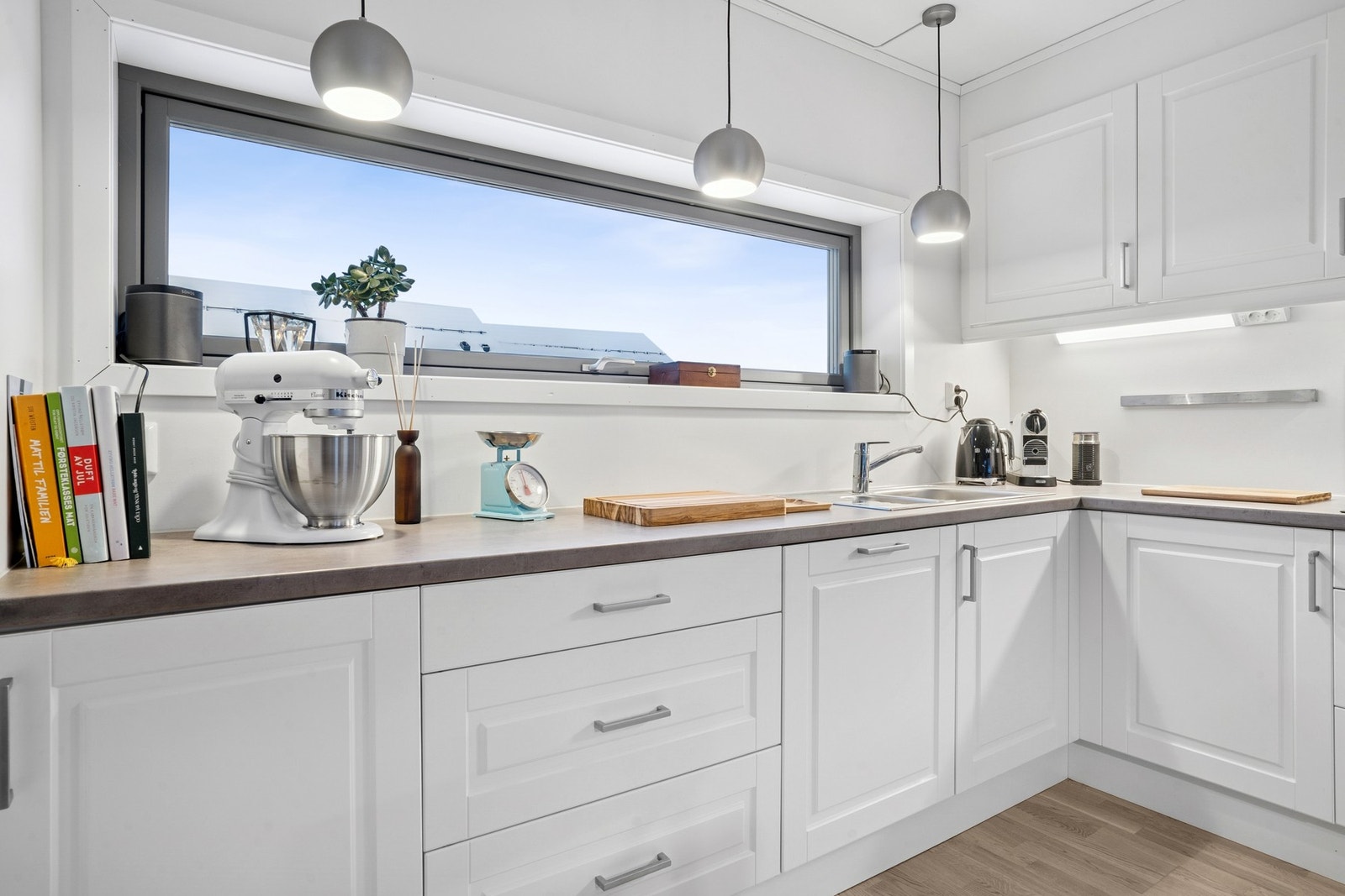 Kjøkken med delvis åpen løsning mot stue. Kjøkkeninnredning fra byggeår med profilerte fronter. Benkeplater av laminat. Nedfelt oppvaskkum i rustfritt stål med ett-greps armatur. Benkskapsbelysning og stikkontakter. Galleribilde