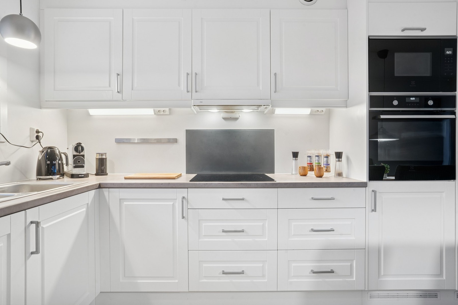 Integrerte hvitevarer. Kjøleskap, fryseskap, oppvaskmaskin, komfyr og mikro i høyskap samt nedfelt induksjonstopp tilkoblet komfyrvakt. Ventilator i overskap tilkoblet avtrekkskanal. Galleribilde