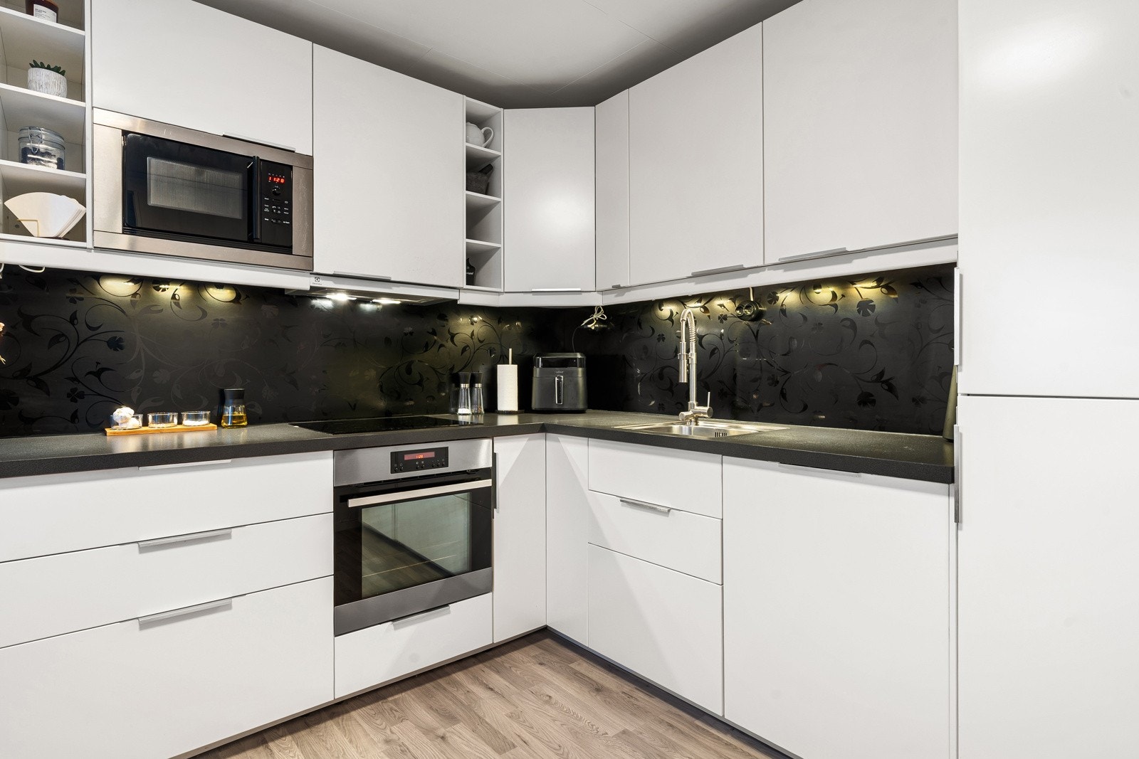 Pen kjøkkeninnredningen med integrert stekeovn, platetopp, micro, kjøl/frys og oppvaskmaskin.