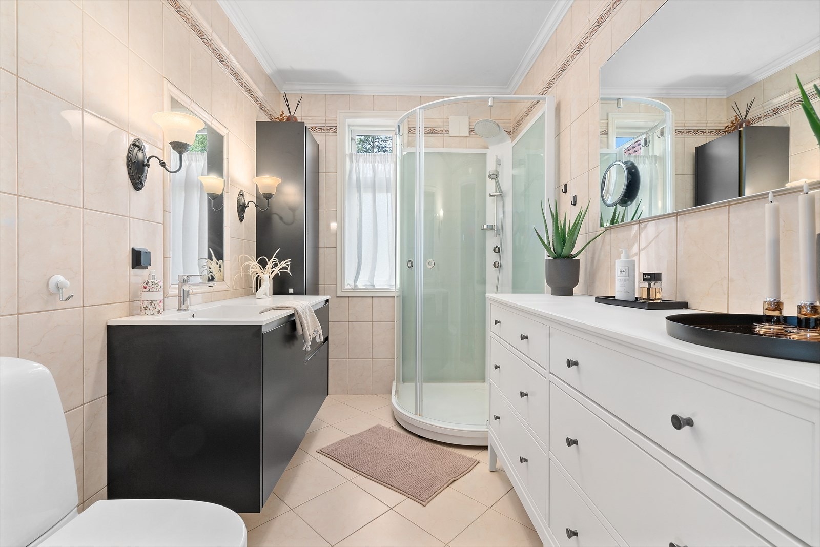 Ved siden av hovedsoverommet ligger det et bad. Badet er innredet med moderne innredning, servant, høyskap, dusjkabinett og toalett. Galleribilde