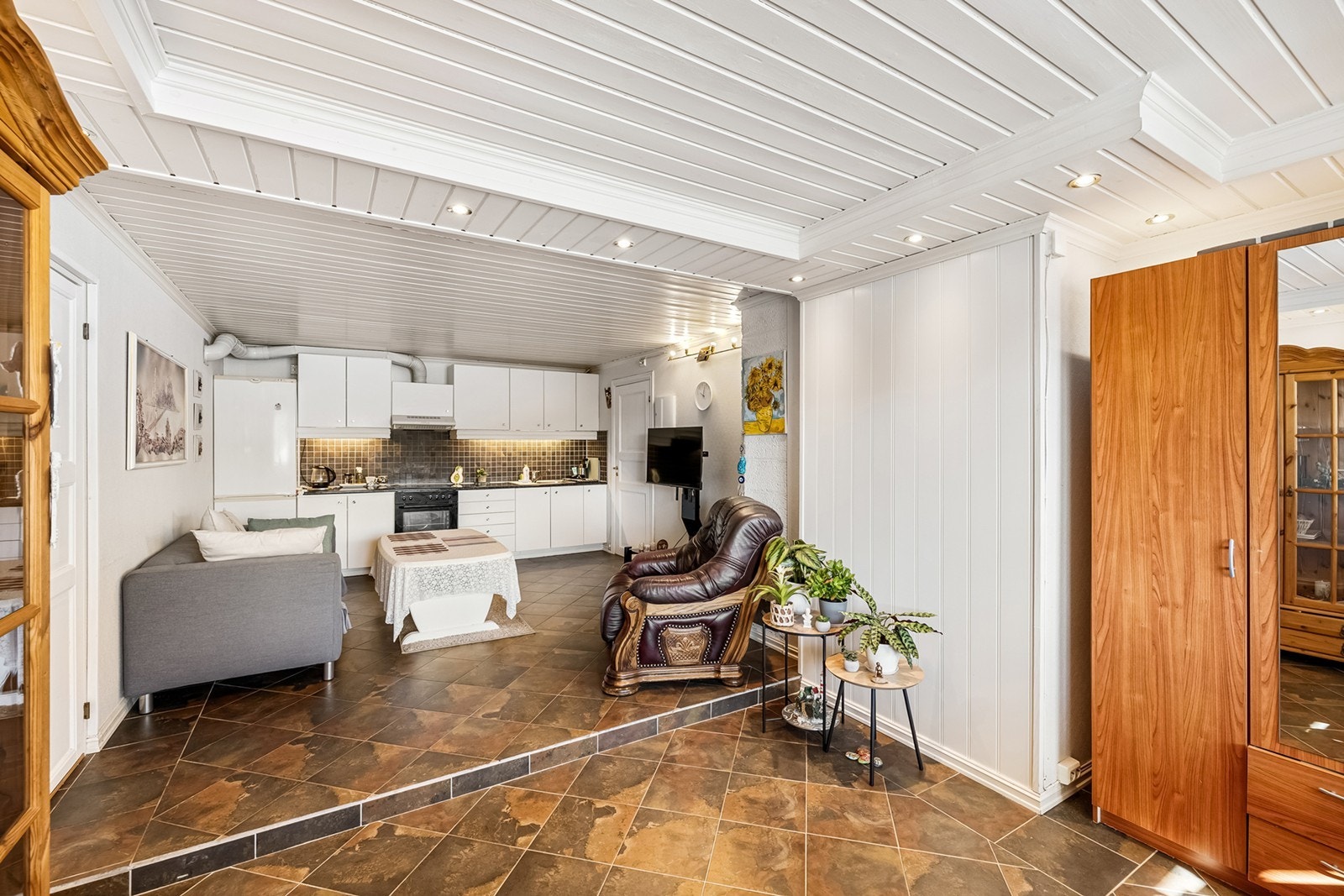 Åpen stue- og kjøkkenløsning i utleiedelen. Bak plantene er det mulig å fjerne veggen for direkte adkomst til hoveddel. Galleribilde