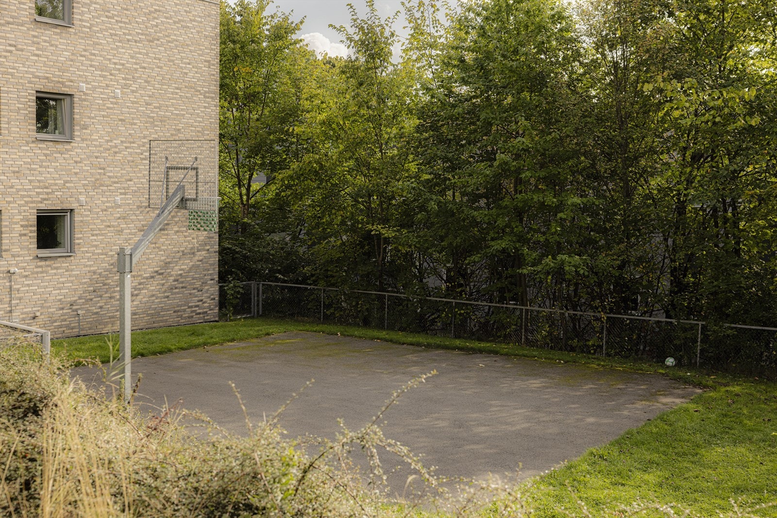 Aktivitet rett utenfor leiligheten med basketballbane på området. Galleribilde