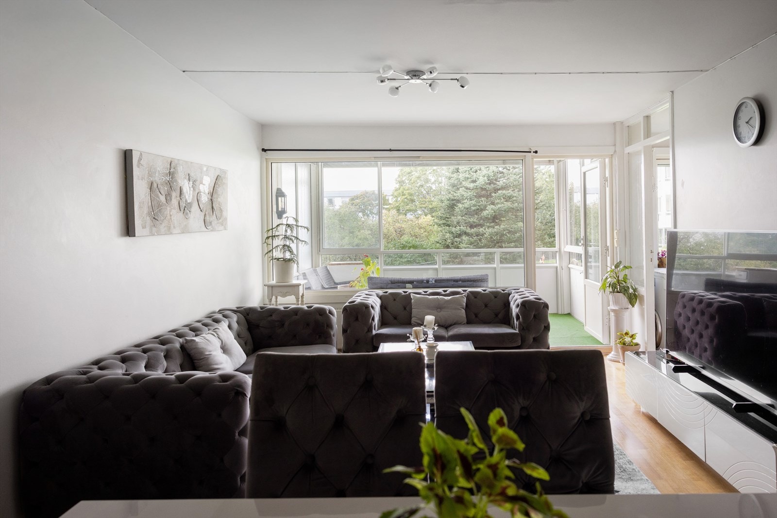 Lys og åpen stue med store vindusflater som slipper inn mye dagslys. Galleribilde