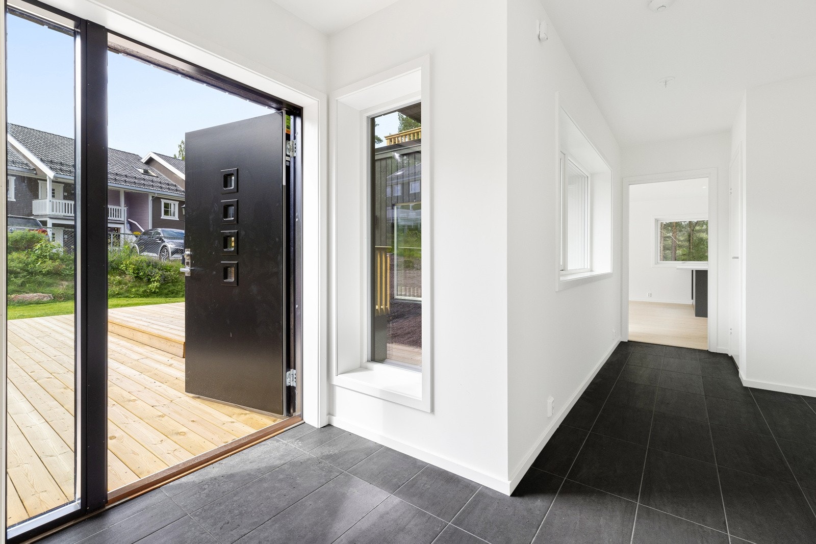 Huset har en innbydende entré med malte vegger og flislagt gulv med behagelig gulvvarme som tørker opp etter våte klær og sko Galleribilde