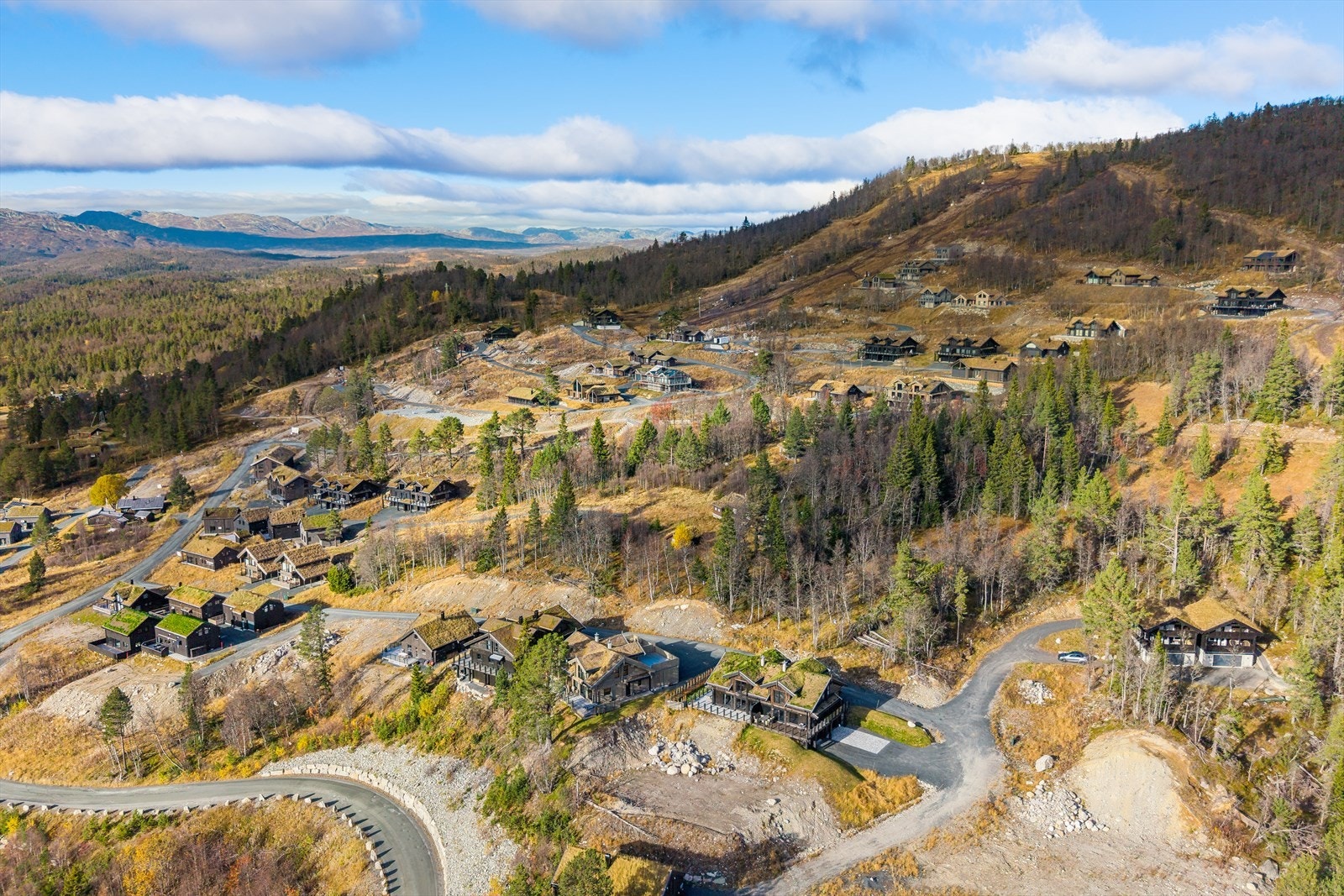 Eiendommen ligger ca. 900 meter over havet og byr på en spektakulær utsikt mot Raulandsfjell. Med vestvendt beliggenhet får hyttene optimale solforhold - perfekte for lange, lyse dager i fjellet. Galleribilde