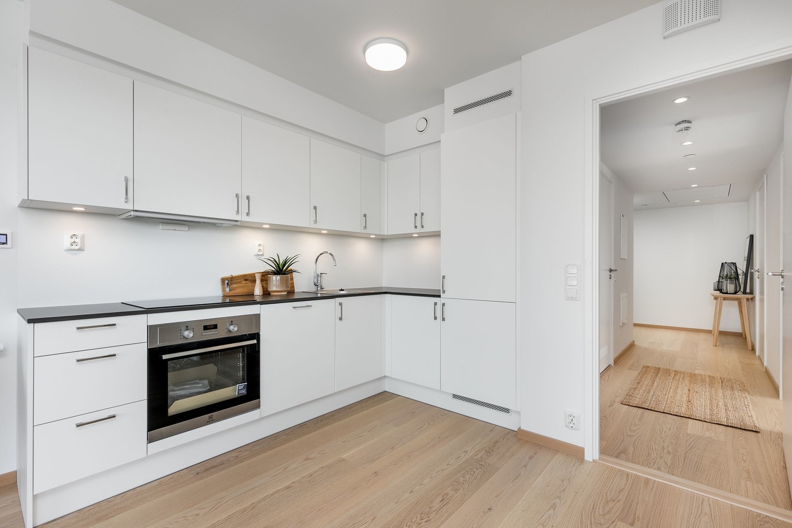 Lekkert kjøkken i åpen løsning mot stue, med integrerte hvitevarer. Bilde fra L707 Galleribilde