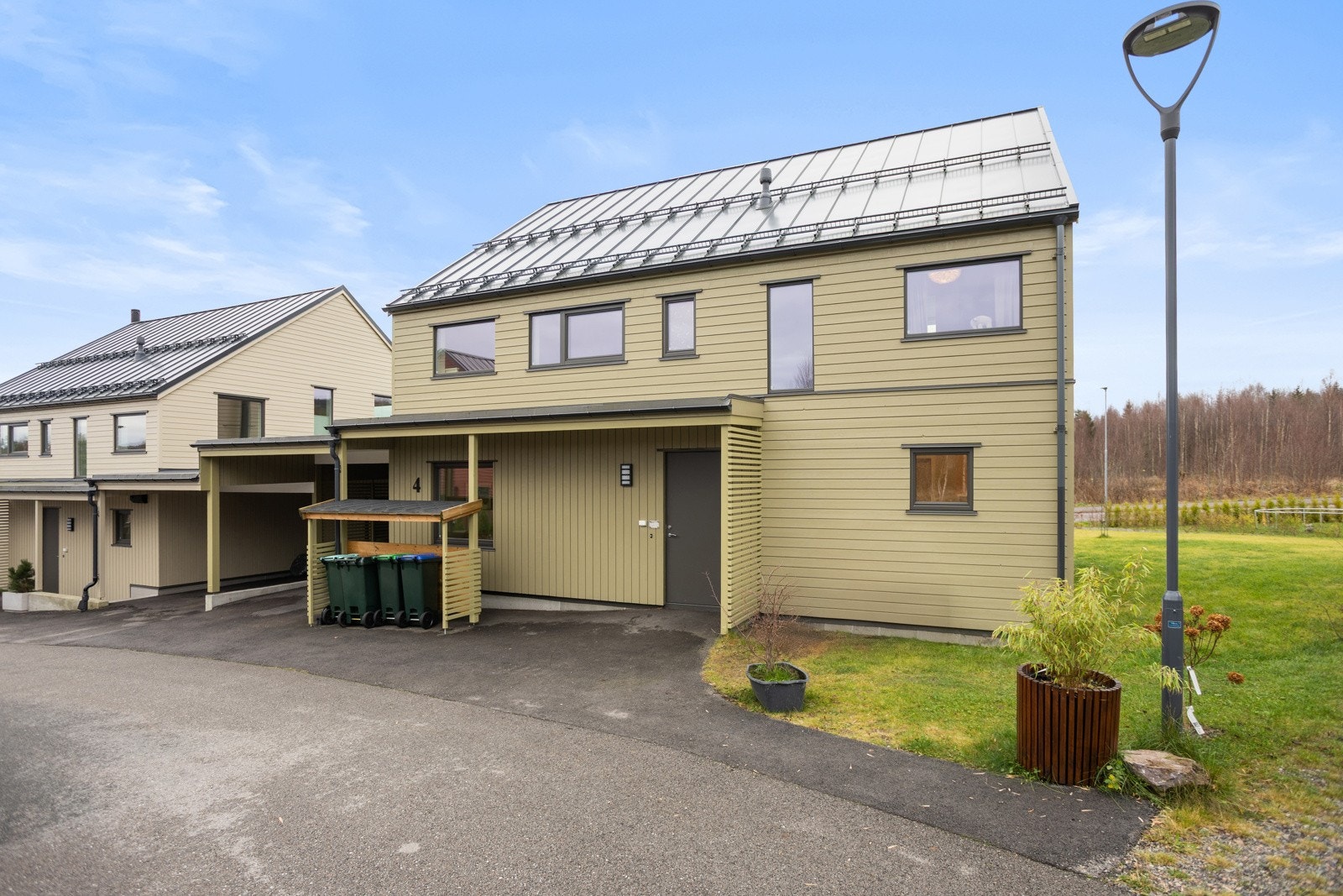 Asfaltert og delvis overbygd inngangsparti. Bilen parkeres i carporten. Galleribilde