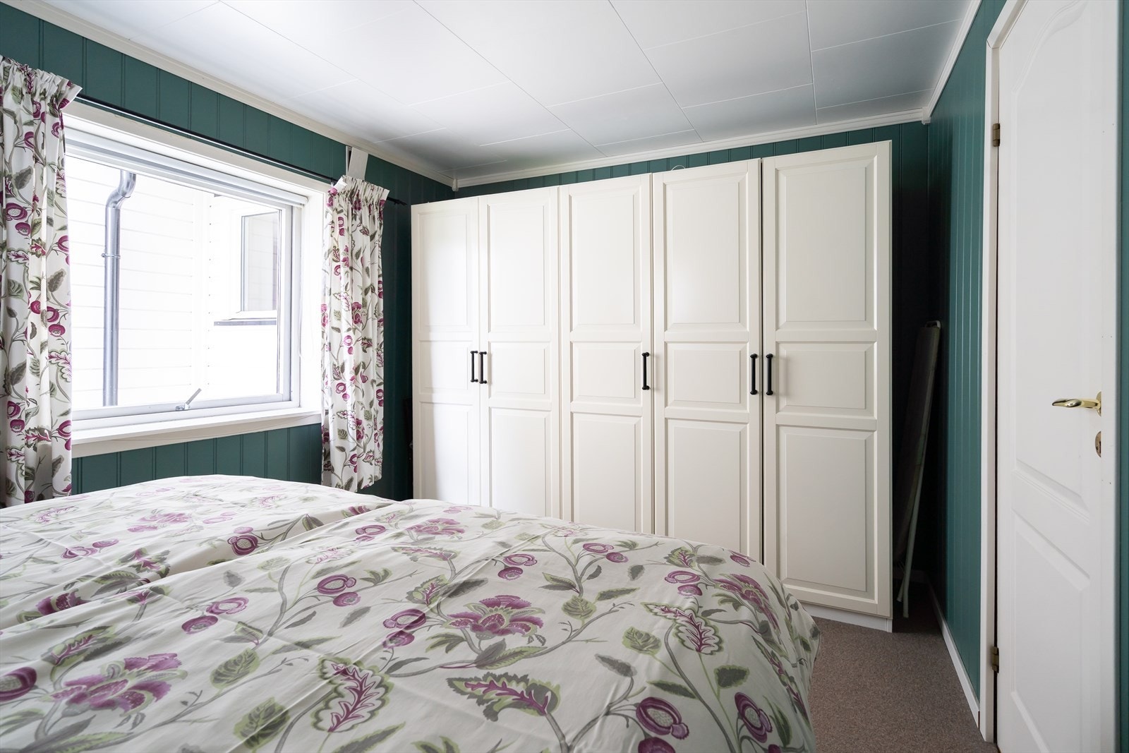 Rommet har en stor garderobe med hvite fronter for effektiv oppbevaring. Galleribilde