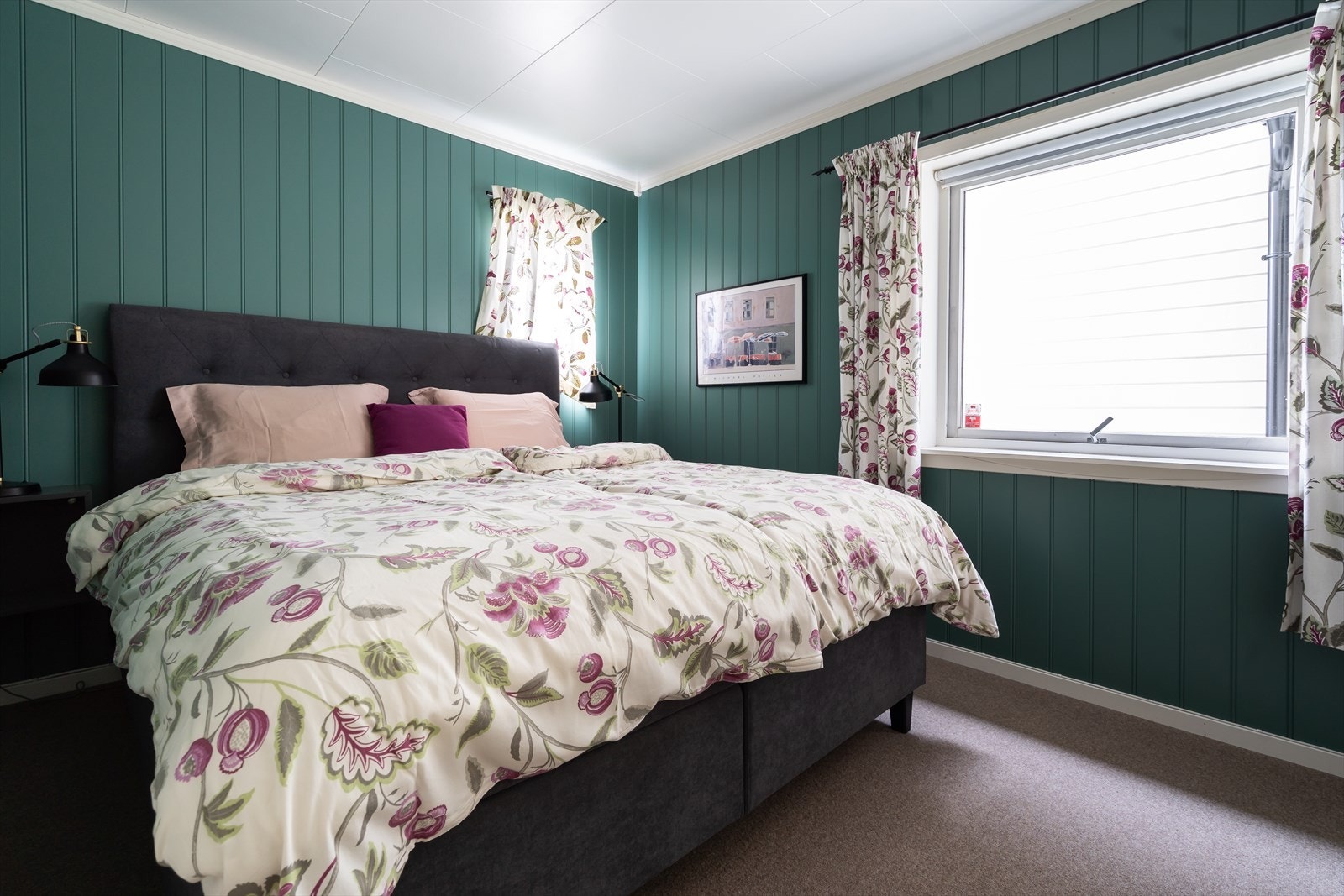 Grønne panelvegger og stor seng gir rommet en avslappet atmosfære. Galleribilde