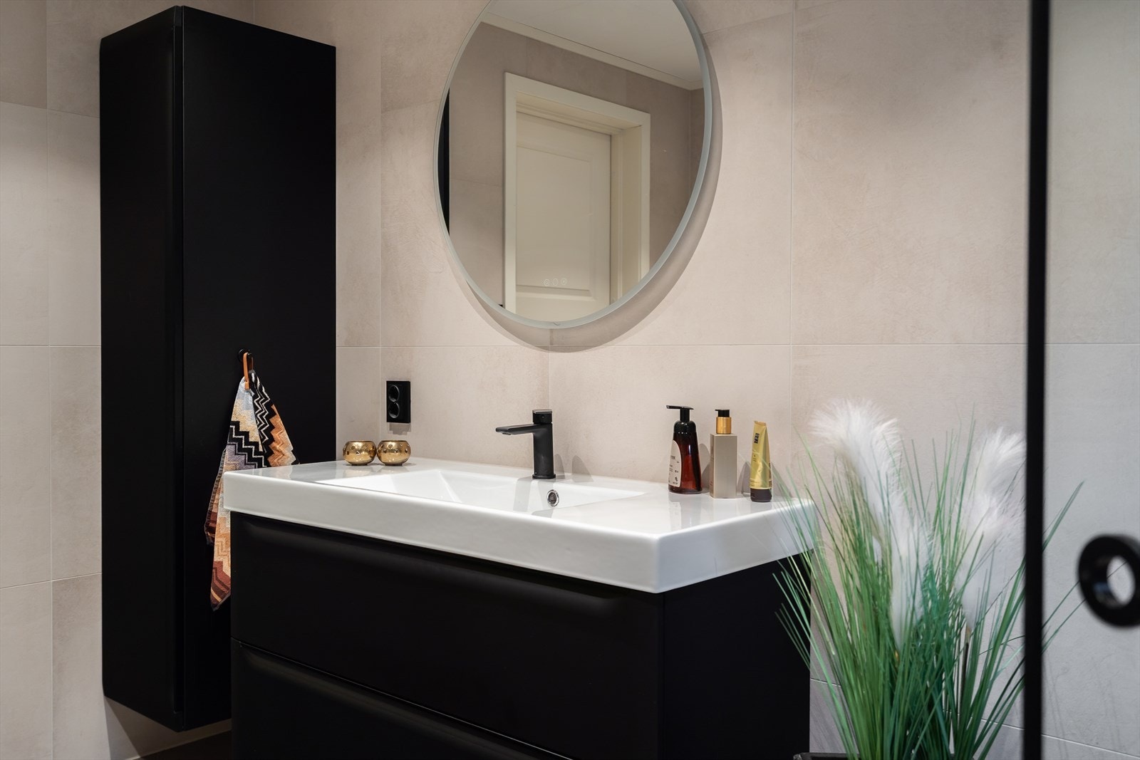 Rundt speil over servant skaper en elegant og funksjonell baderomsløsning. Galleribilde