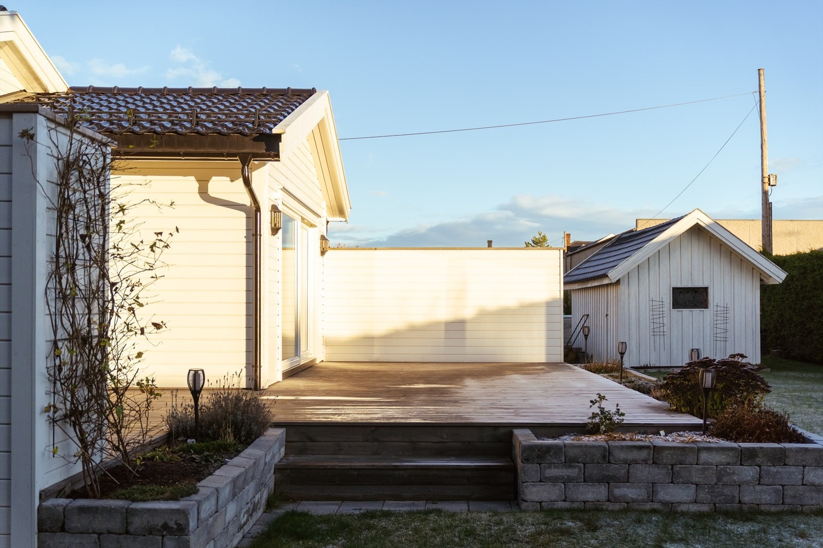 Treplatting strekker seg langs husveggen med tilgang til hage. Galleribilde