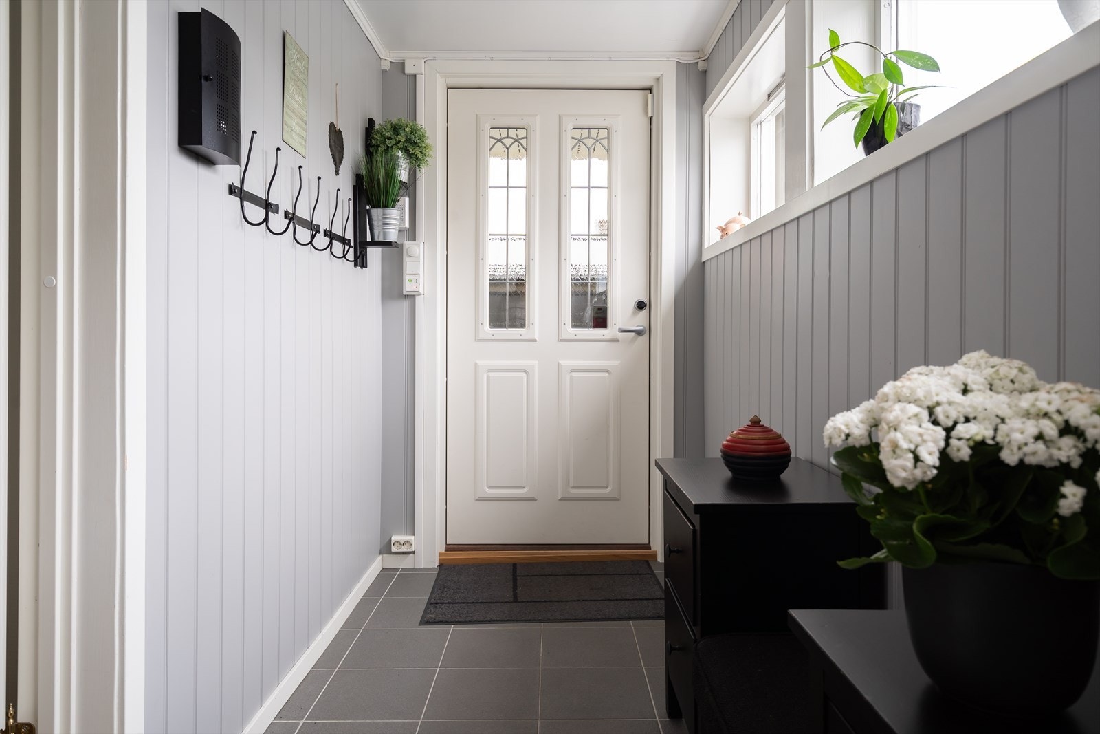 Lysinnslipp fra vinduer langs veggen skaper en innbydende atmosfære i gangen. Galleribilde