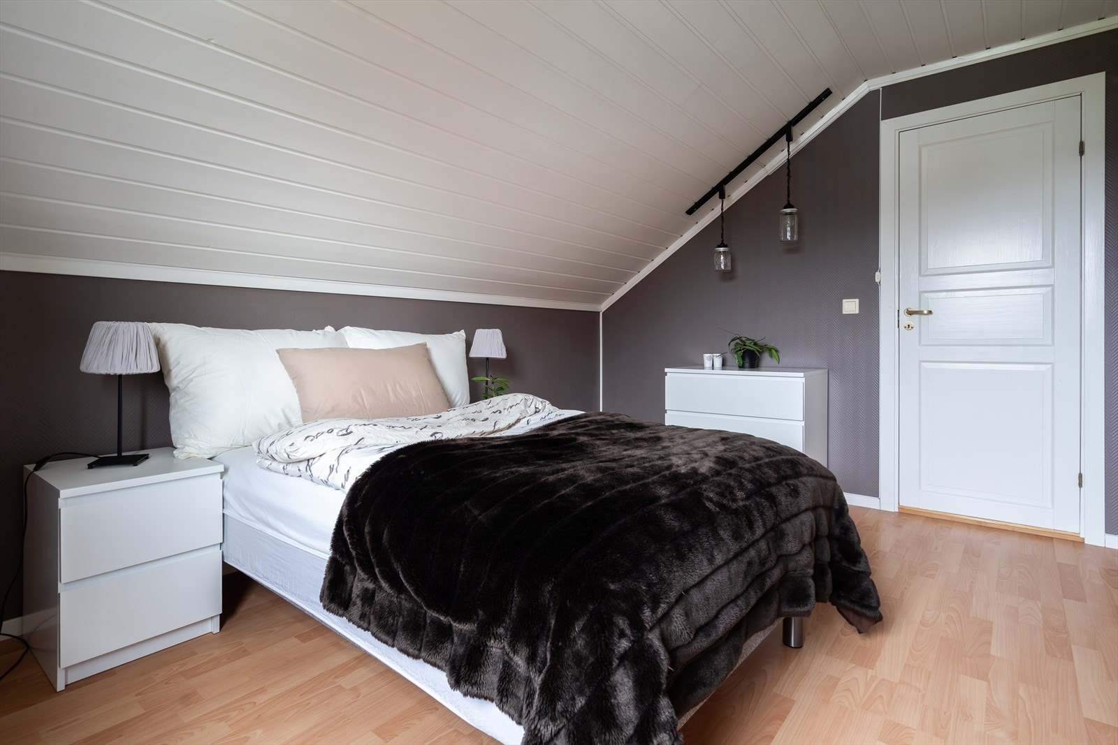 Skråtaket gir rommet en koselig følelse med mørke vegger. Galleribilde