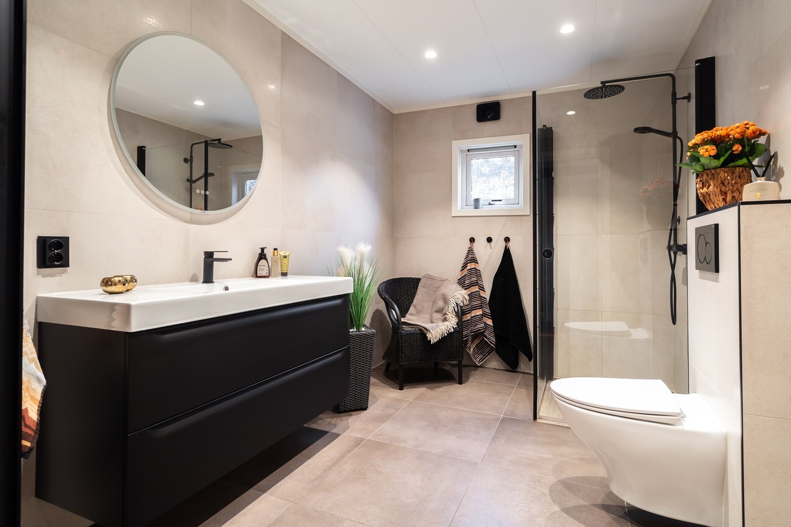 Flislagte overflater og dusjnisje med glassvegger gir et stilrent uttrykk. Galleribilde