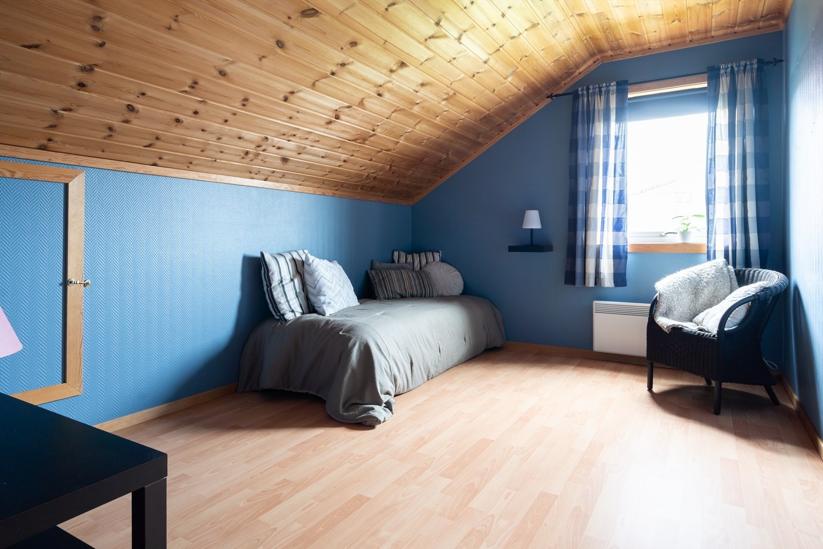 Trepanel i taket og blå vegger gir en lun atmosfære. Galleribilde