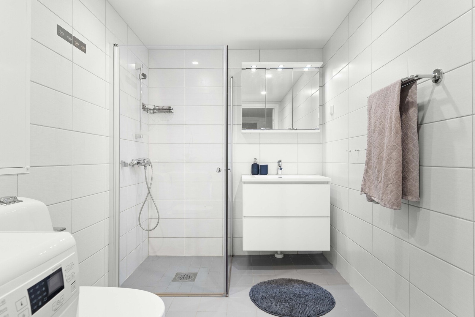 Badet er utstyrt med vegghengt toalett og opplegg for vaskemaskin. Galleribilde