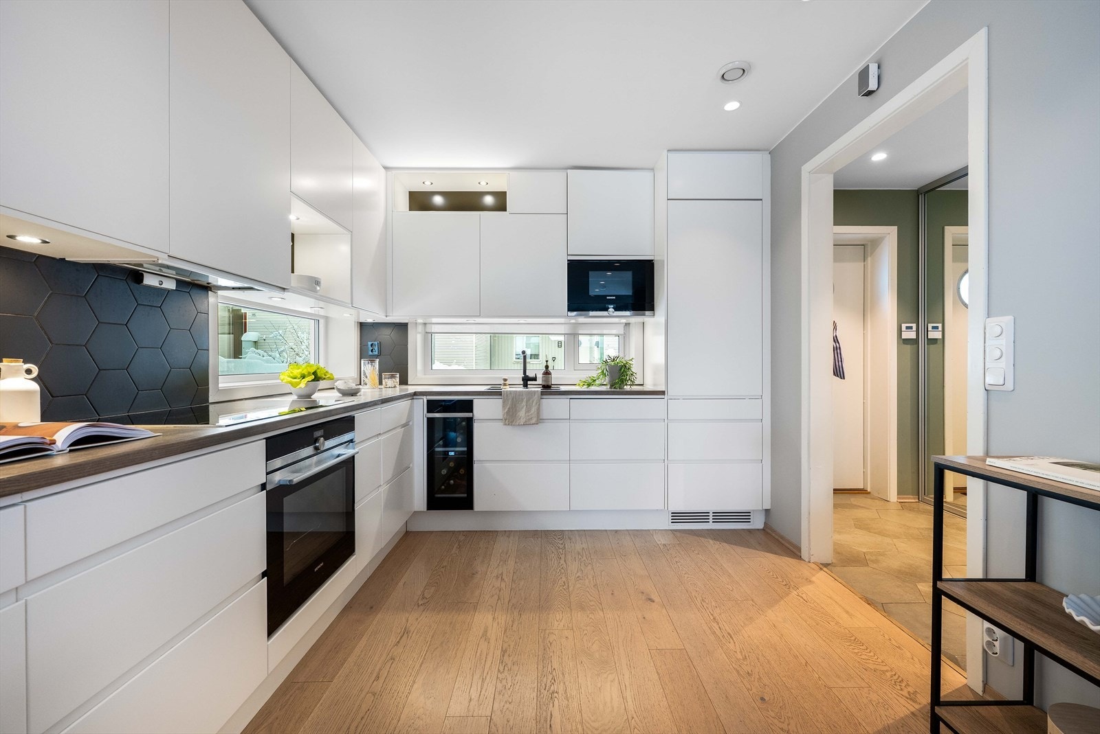 Det er integrert stekeovn, platetopp, mikro, oppvaskmaskin, vinskap og kjøleskap. Videre er det hexagonfliser over benk med benkebelysning. Galleribilde