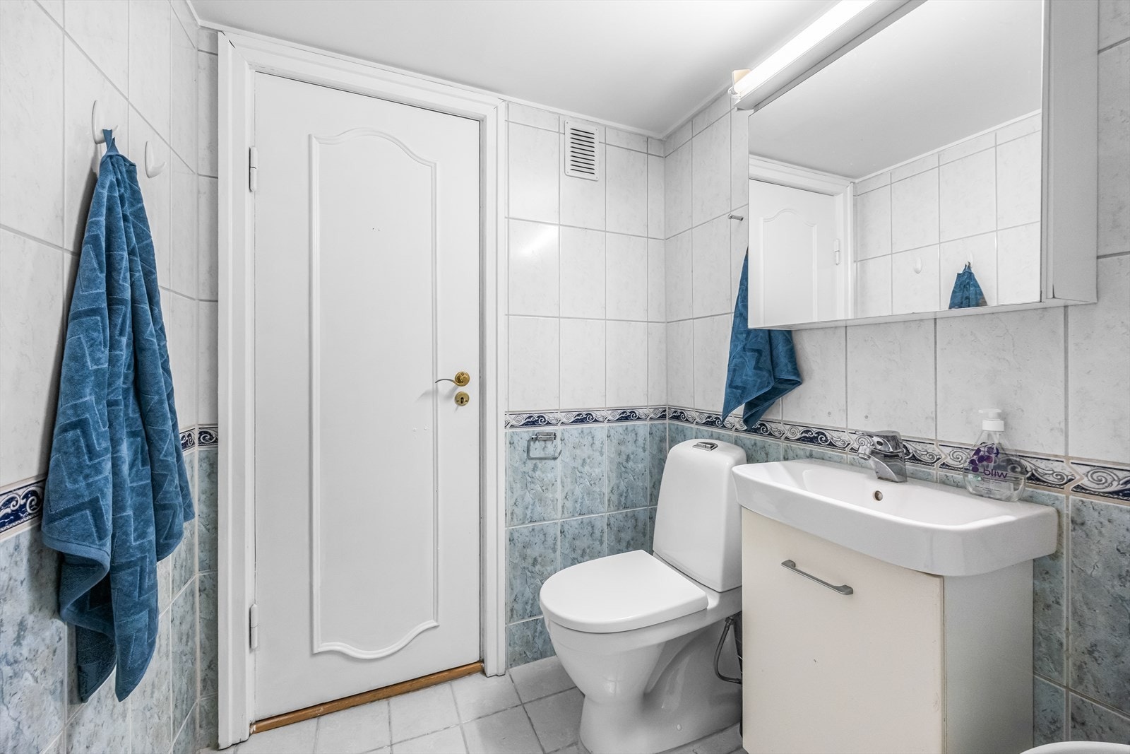 Badet har servant med underskap, speilskap og vegghengt toalett. Galleribilde