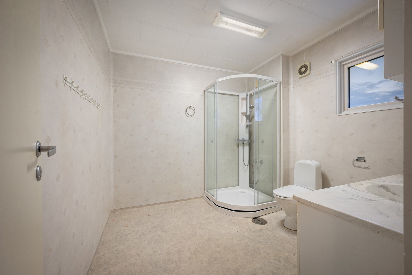 Badet har servantinnredning, toalett og dusjkabinett Galleribilde