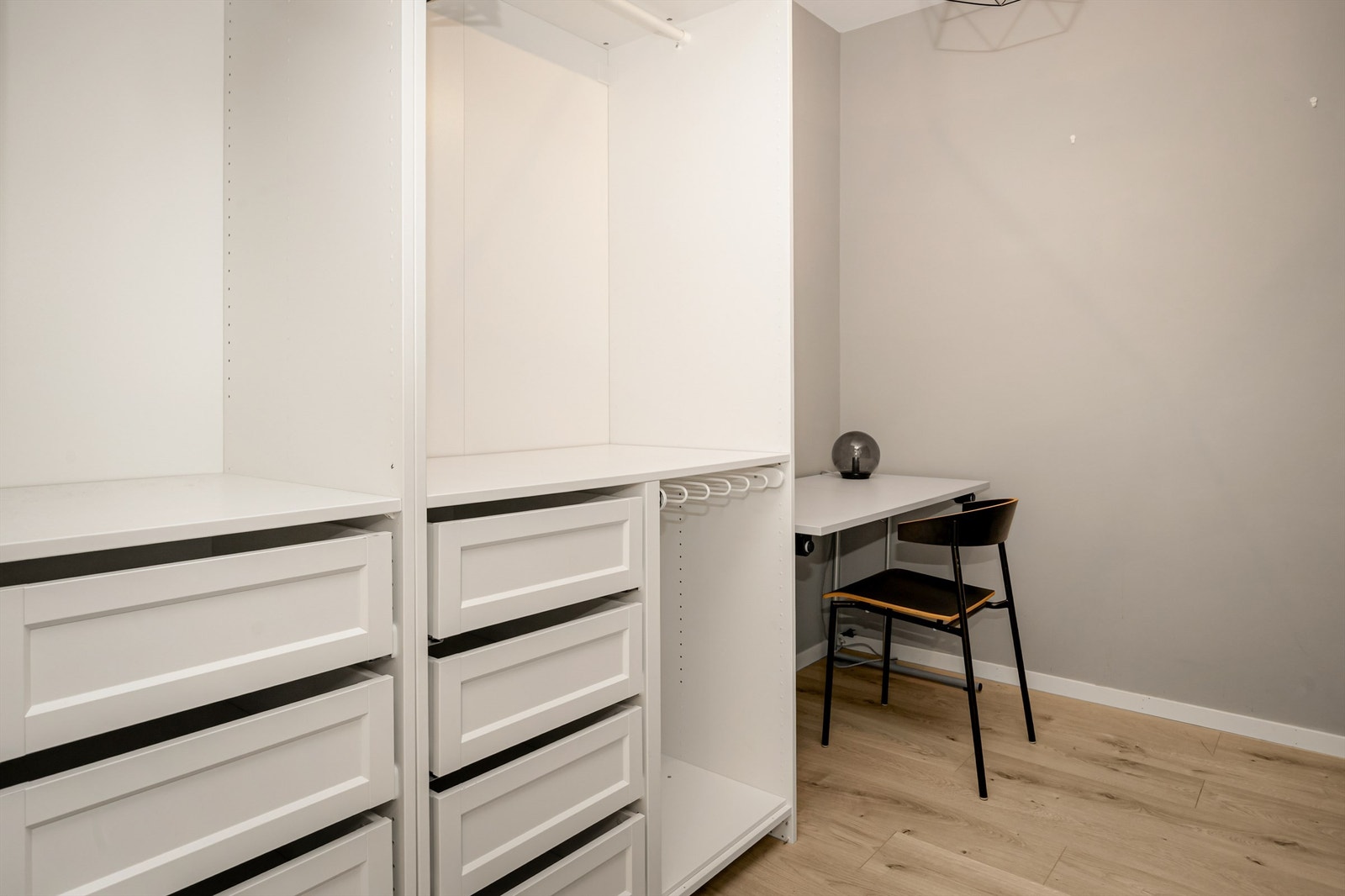 Innvendig bod med garderobeløsning - To åpne garderobeskap i hvit og profilert utførelse Galleribilde