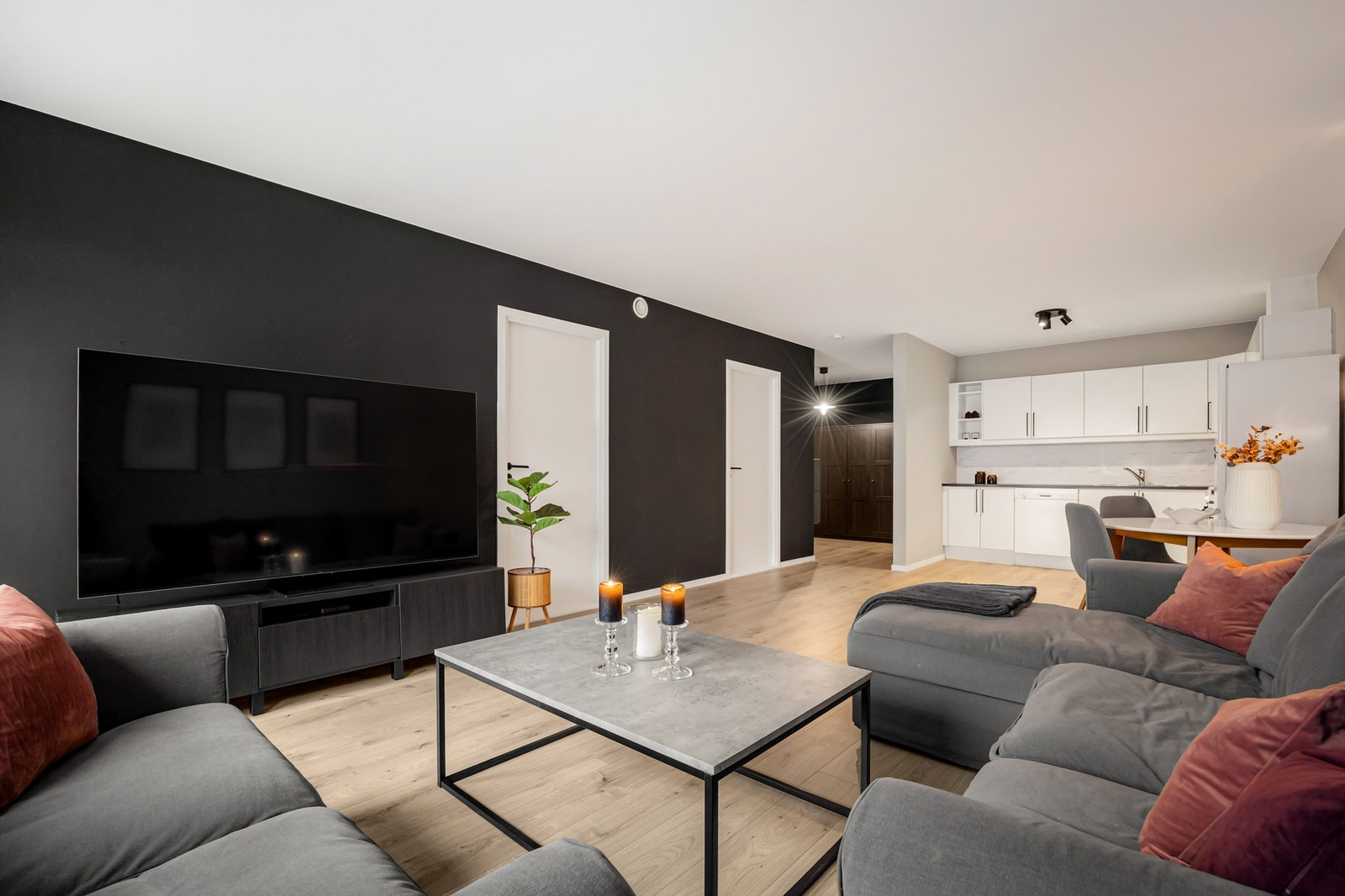 Åpen kjøkken- og stueløsning med sofaområde samt spiseplass Galleribilde